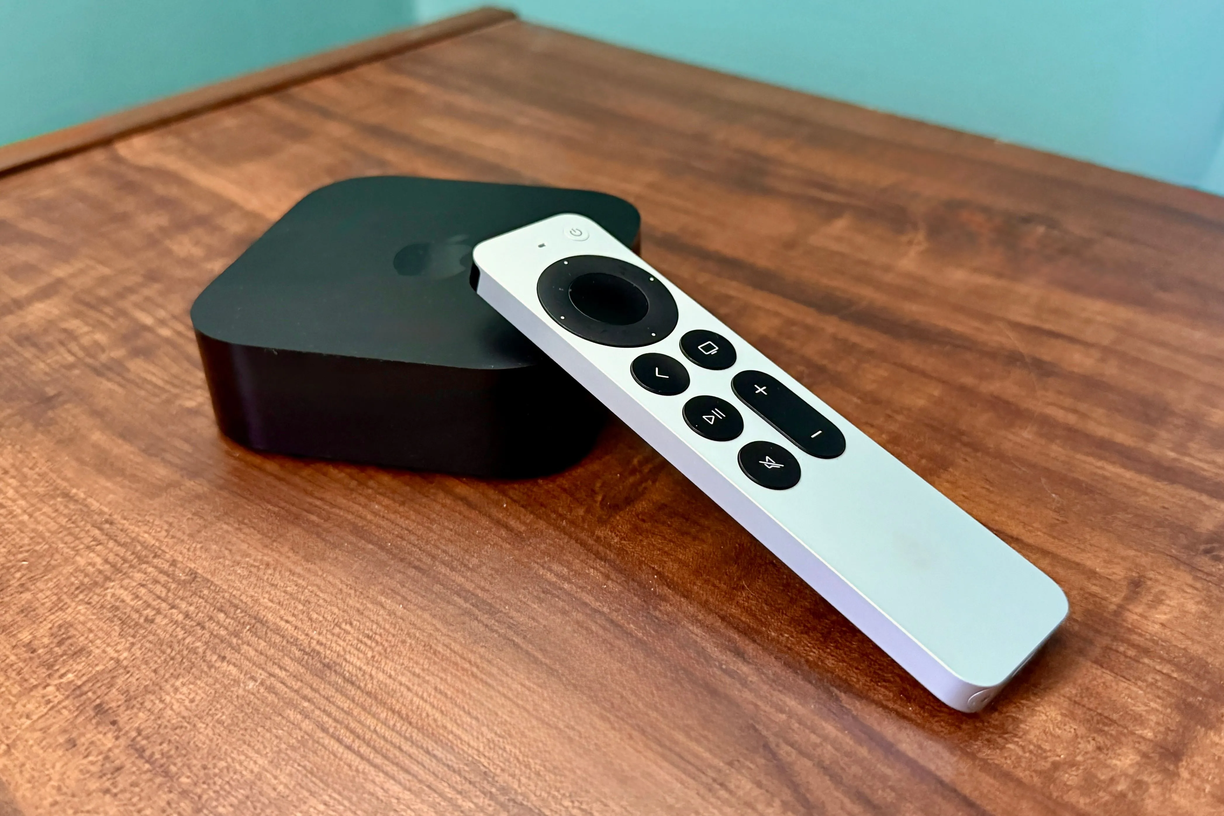 Apple TV 4K và điều khiển từ xa đặt trên bàn gỗ