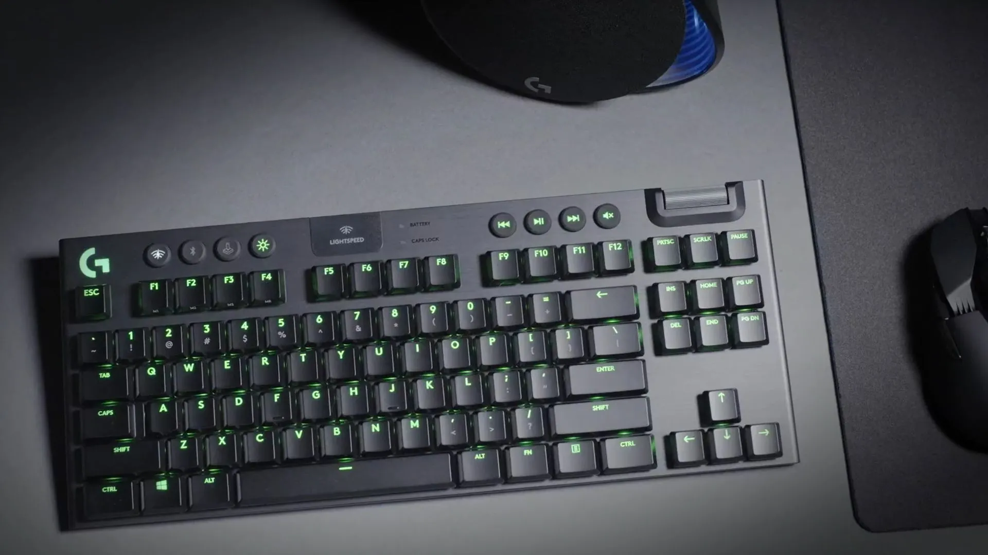 Bàn phím Logitech G915 Lightspeed TKL không dây màu đen đặt trên bàn làm việc màu xám, thể hiện sự sang trọng và tiện lợi của bàn phím cơ TKL không dây.