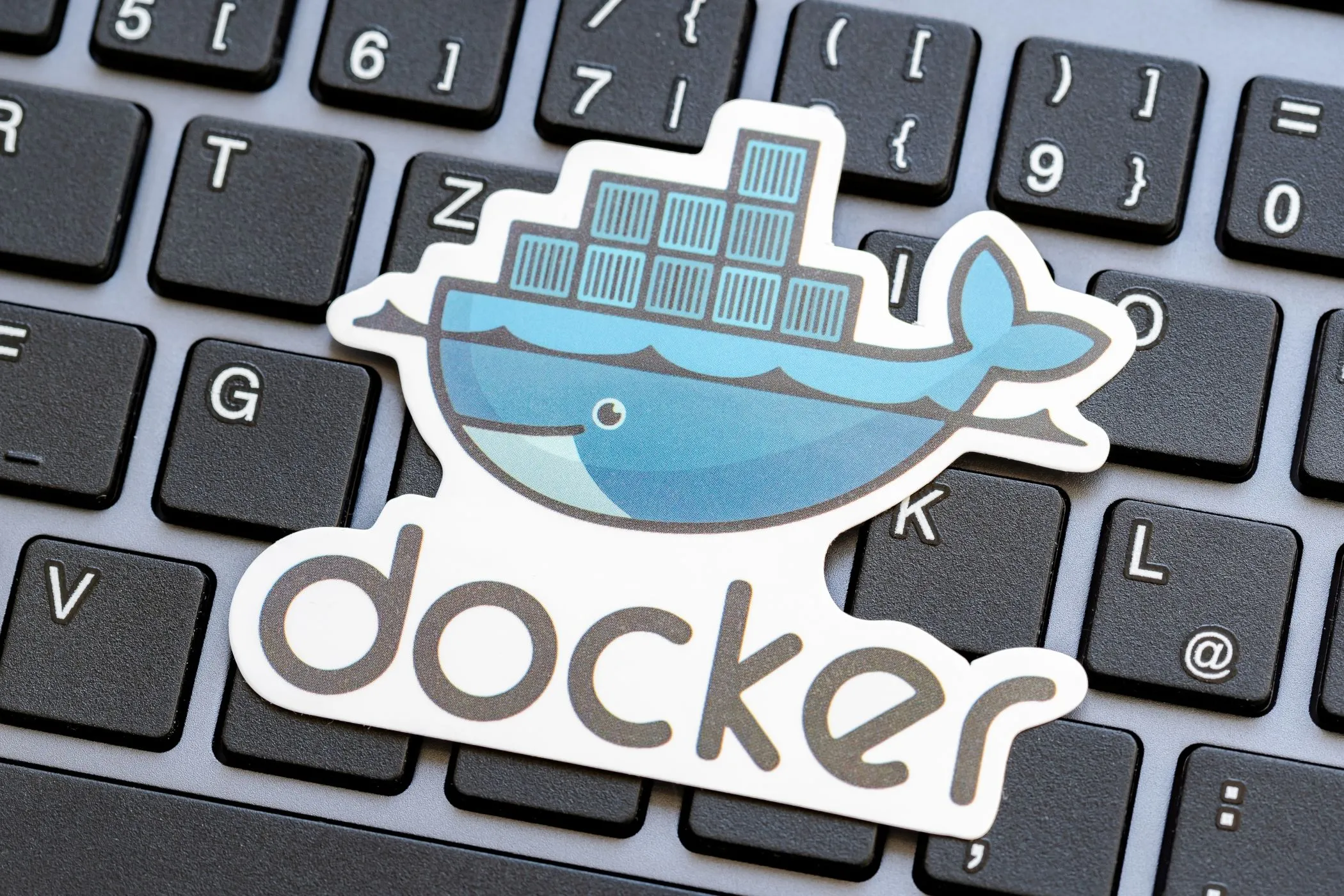 Biểu tượng Docker đặt trên nền bàn phím máy tính xách tay, thể hiện sự liên quan đến công nghệ.
