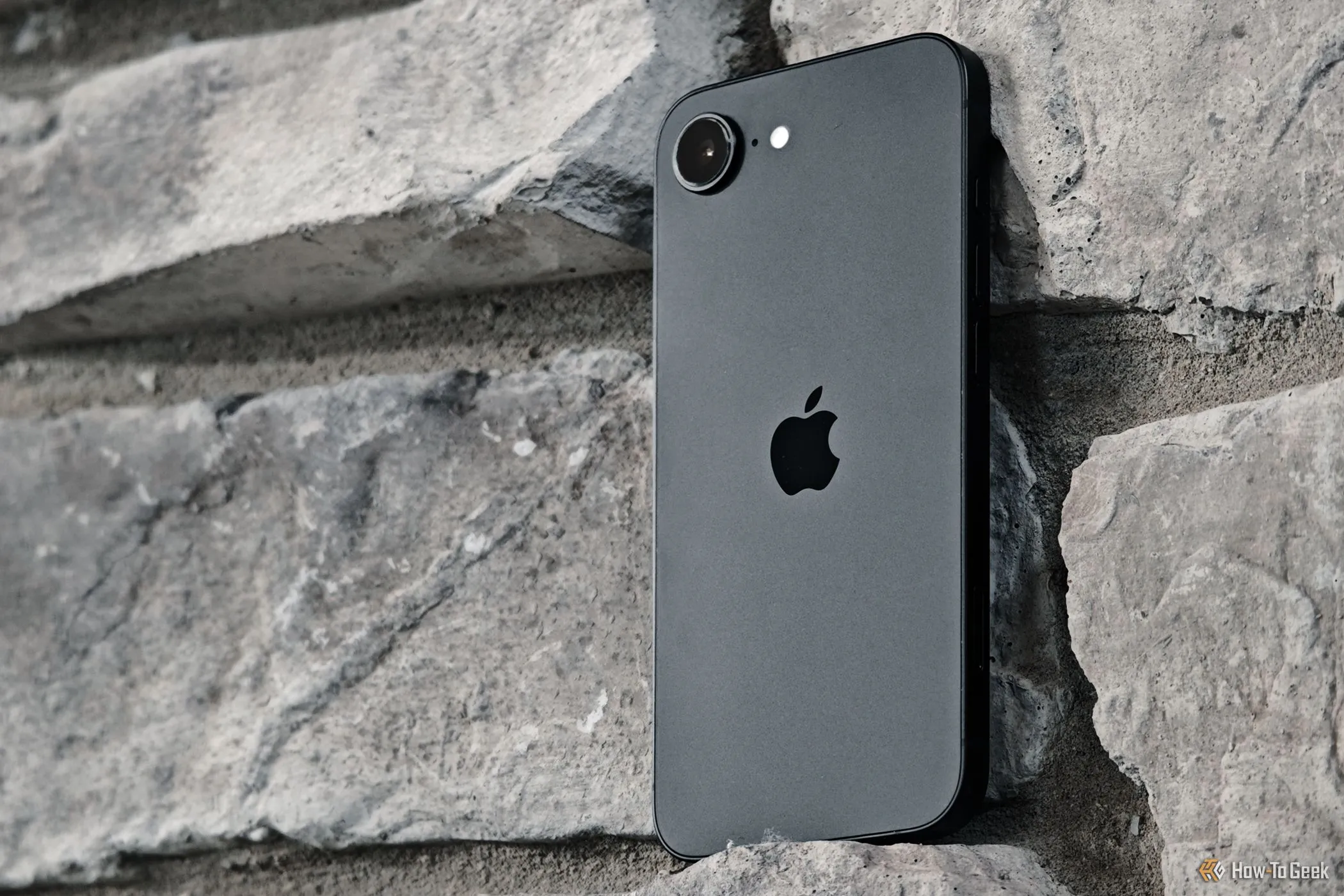 iPhone 16e dựa vào tường gạch