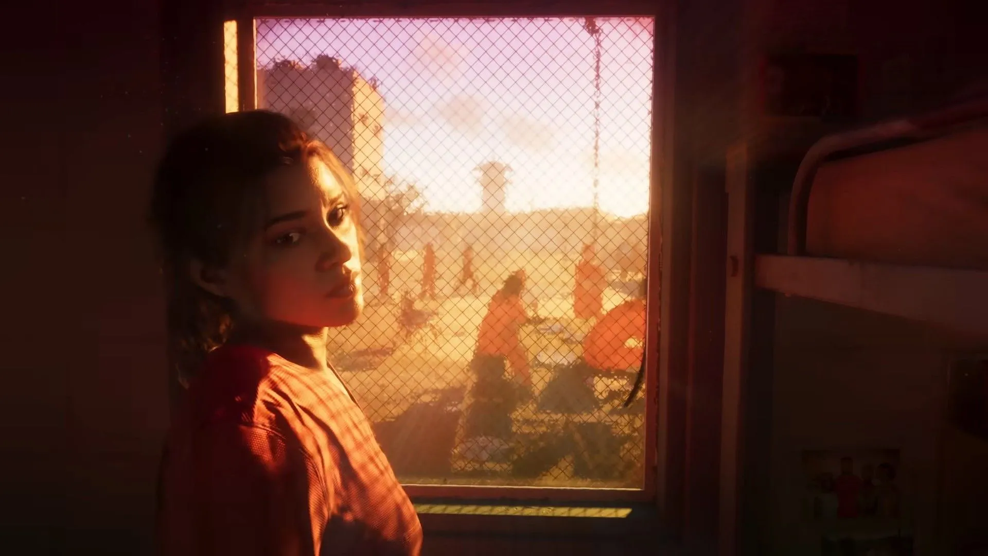 Lucia trong Grand Theft Auto VI nhìn ra ngoài cửa sổ nhà tù, cảnh quay mở đầu trailer, thể hiện khởi điểm câu chuyện của nhân vật