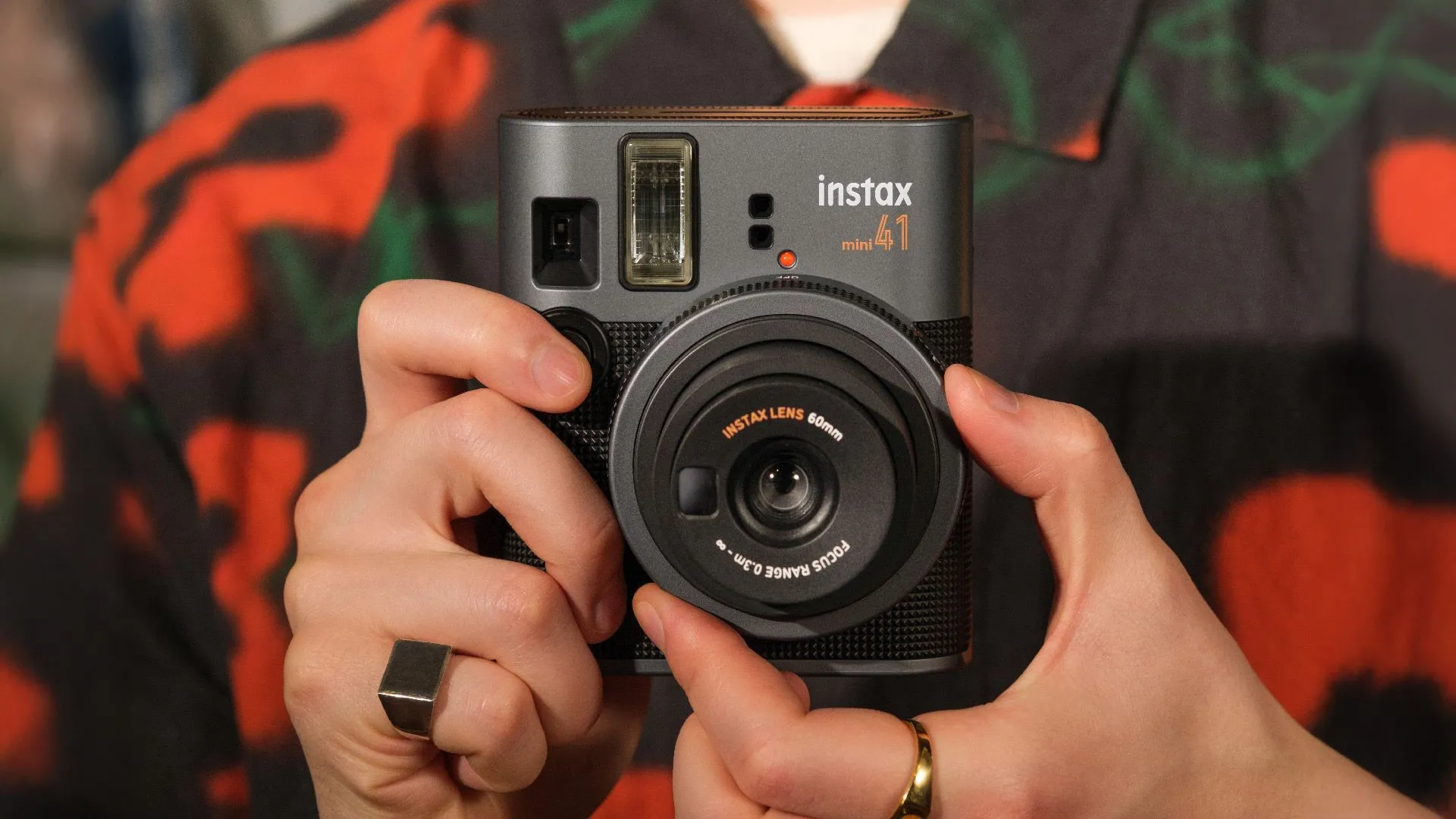 Máy ảnh Fujifilm Instax Mini 41 màu xanh nhạt đặt trên bề mặt màu hồng