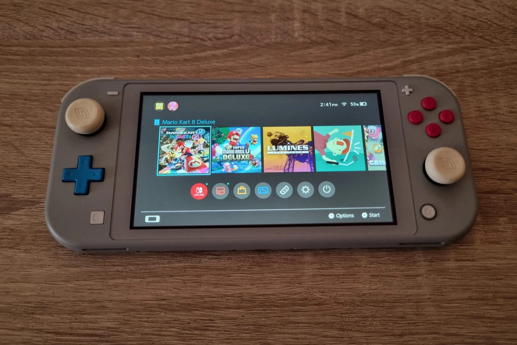 Máy chơi game cầm tay Nintendo Switch Lite màu vàng đặt trên nền trơn, thiết kế nhỏ gọn.