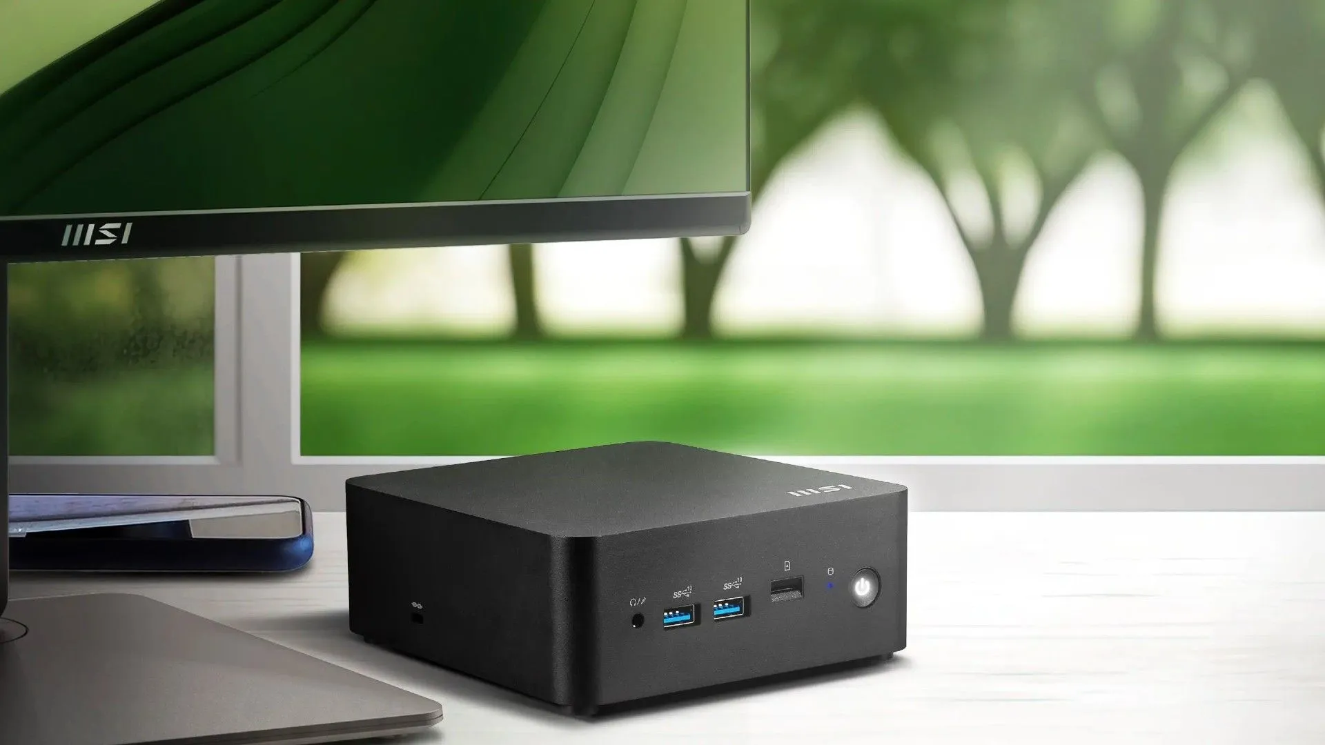 Máy tính mini MSI Cubi NUC AI Series đặt cạnh màn hình, nhỏ gọn nhưng mạnh mẽ