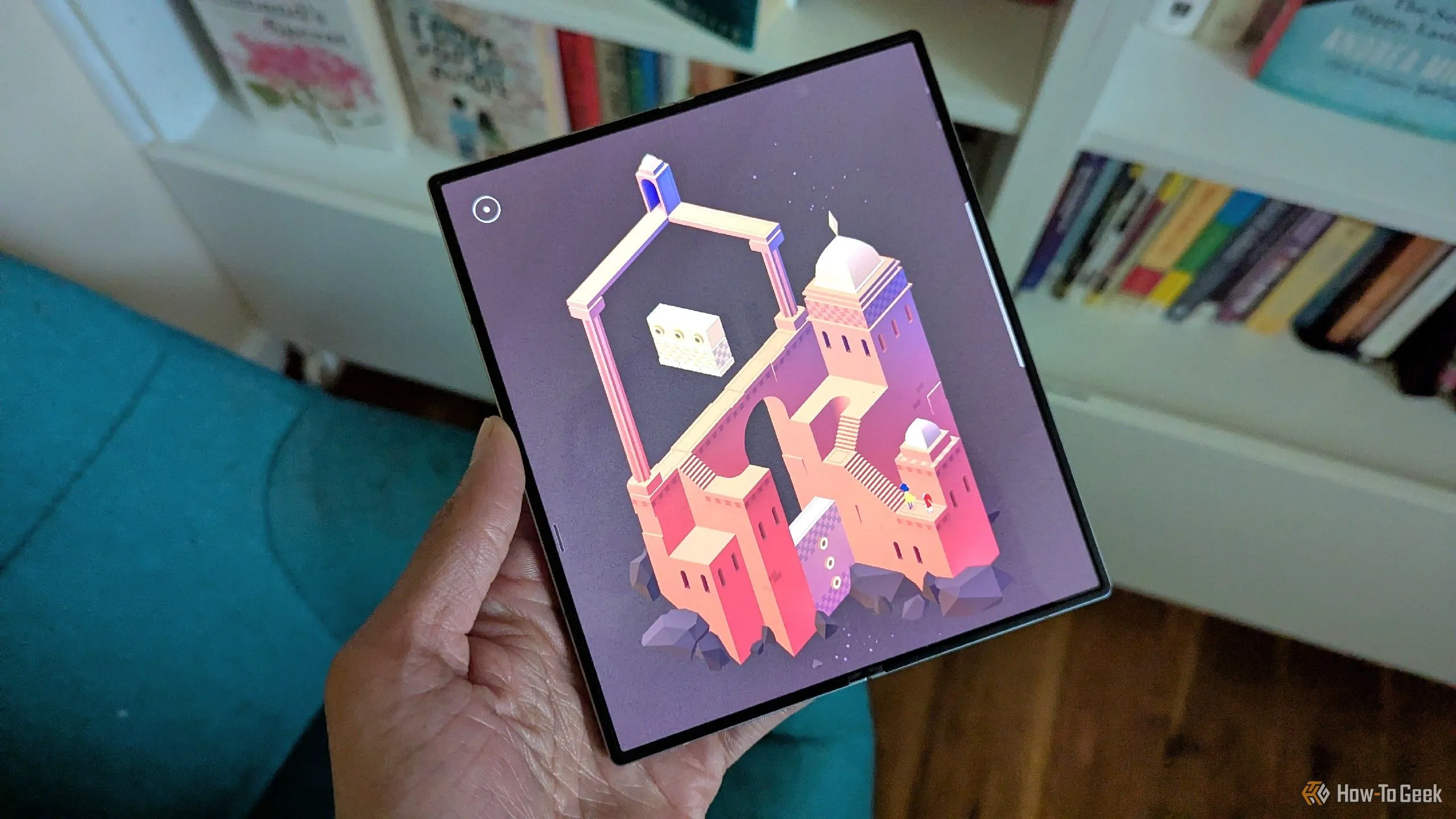 Monument Valley 2 trên màn hình Galaxy Z Fold 6, nền là những cuốn sách.