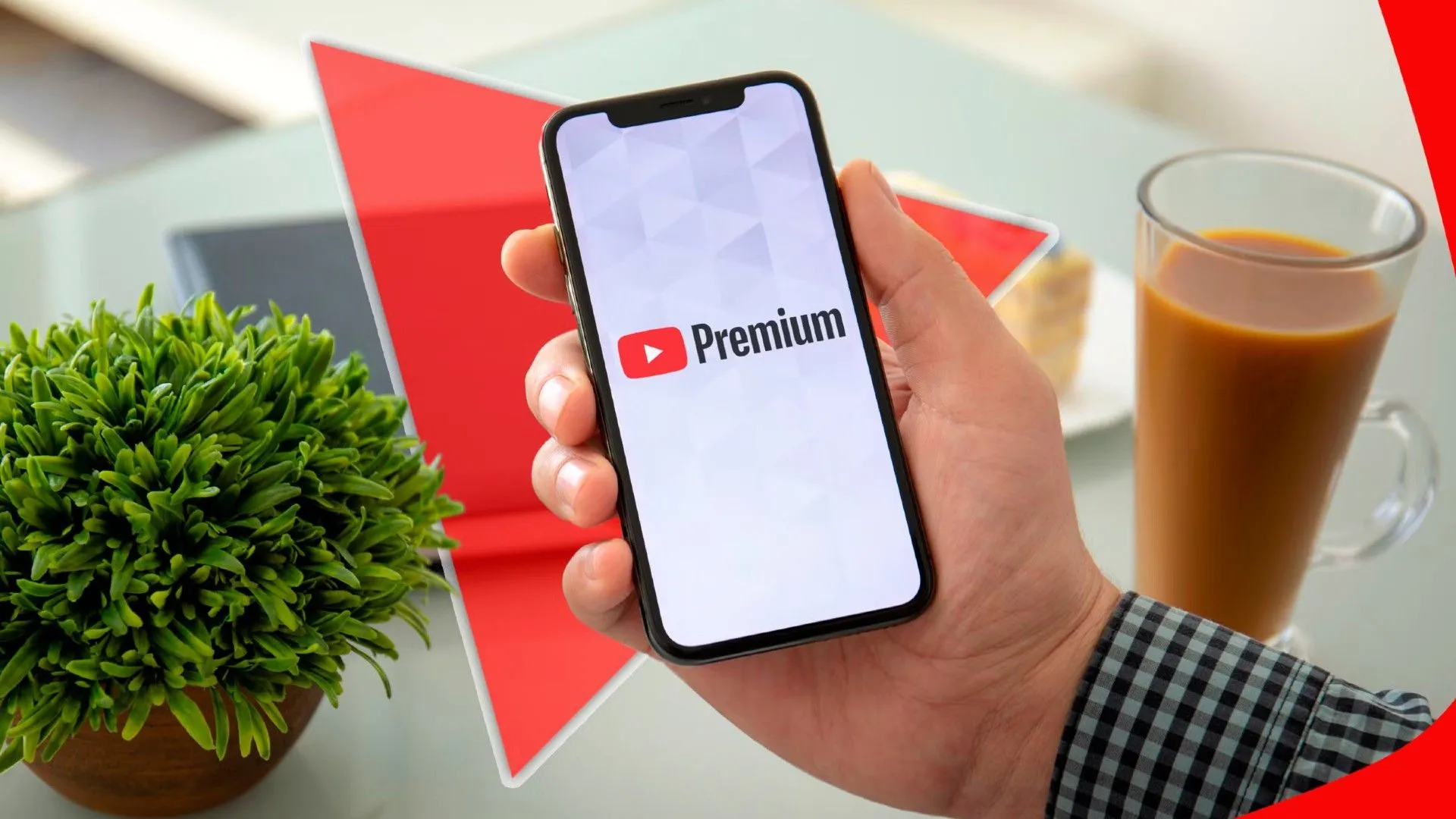 Một bàn tay cầm điện thoại với logo YouTube Premium hiển thị trên màn hình