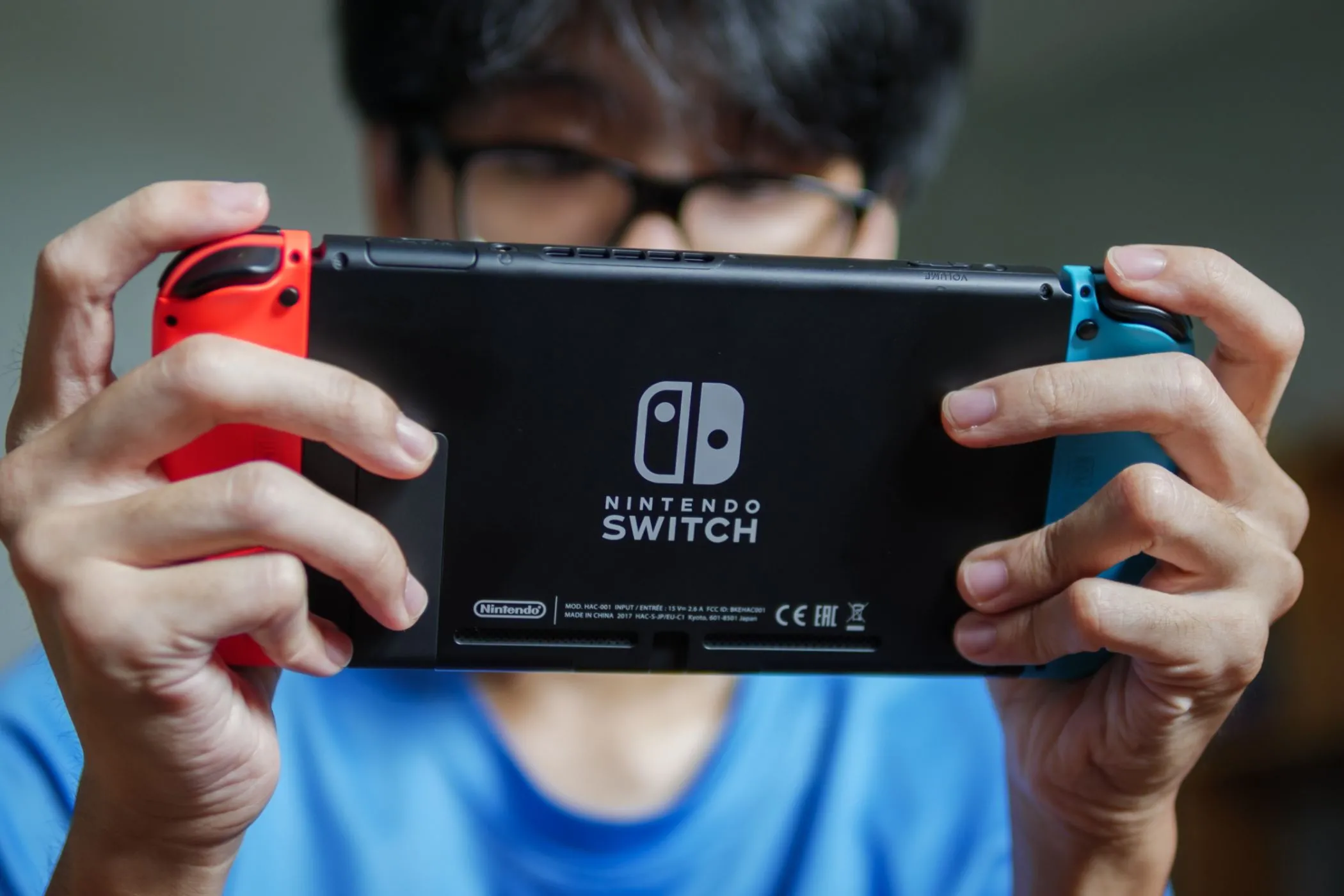 Một người đàn ông đang chơi Nintendo Switch ở chế độ cầm tay