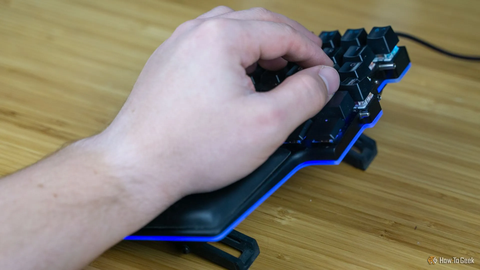 Một người dùng thao tác với các phím ngón cái trên bàn phím Dygma Raise, minh họa khả năng tùy chỉnh macro tiện lợi.