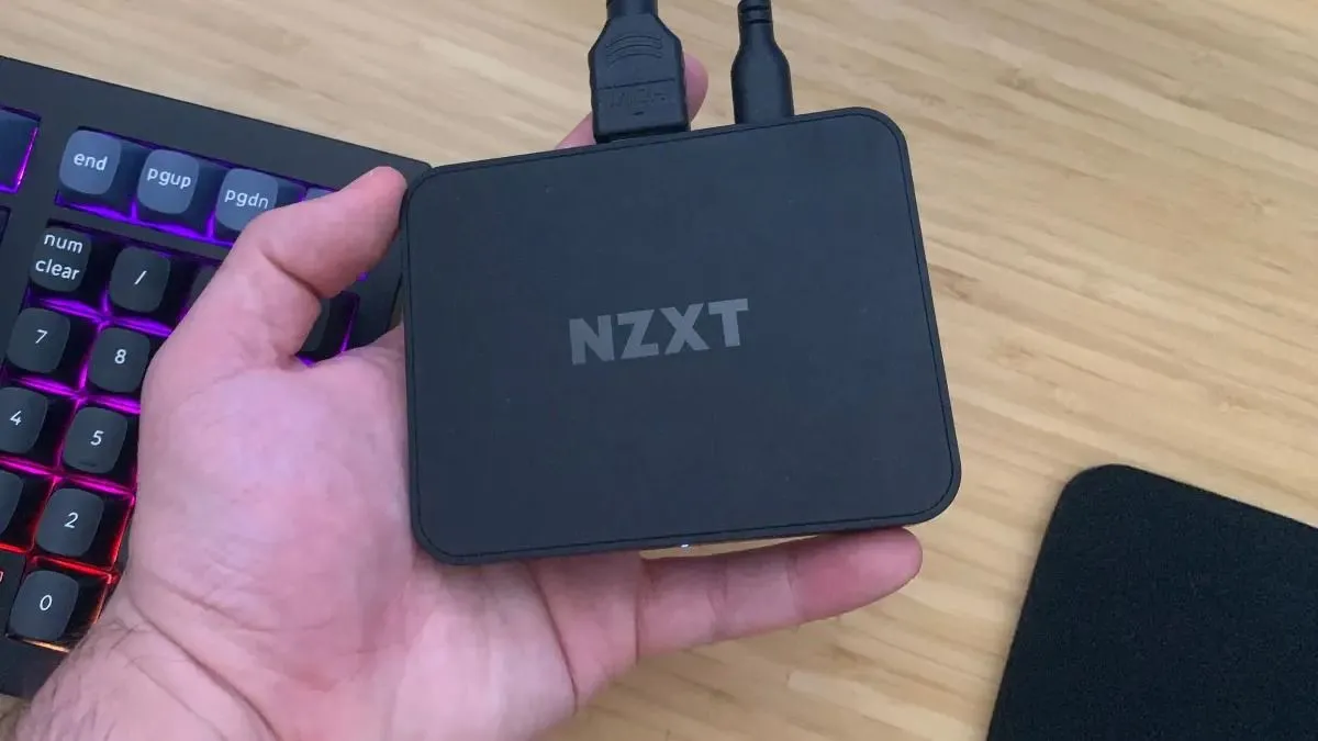Người cầm thiết bị thu hình (capture card) NZXT Signal 4K30, minh họa giải pháp ghi hình game chuyên nghiệp.