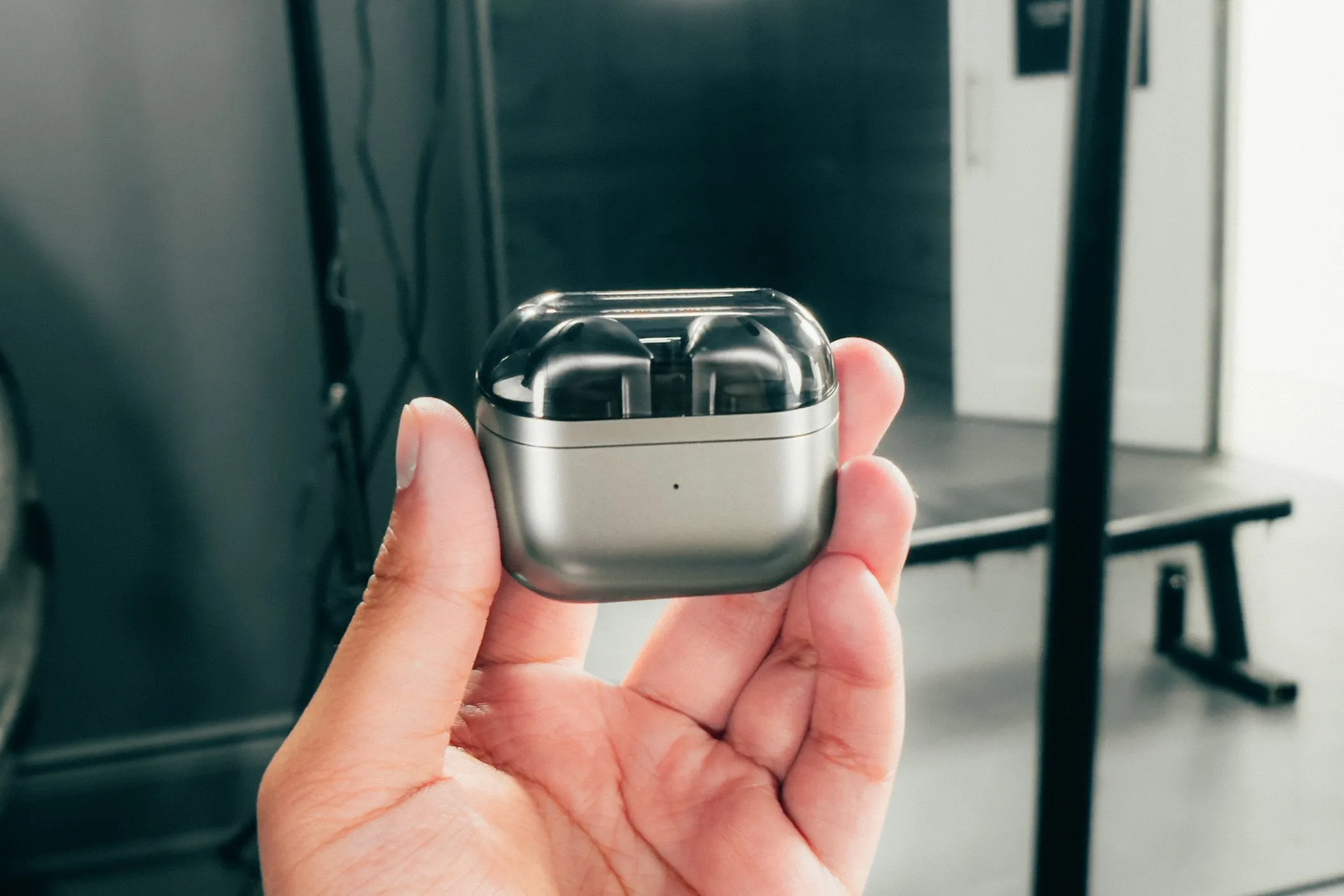 Tai nghe Samsung Galaxy Buds 3 nằm trong hộp sạc đóng nắp, được giữ trong tay