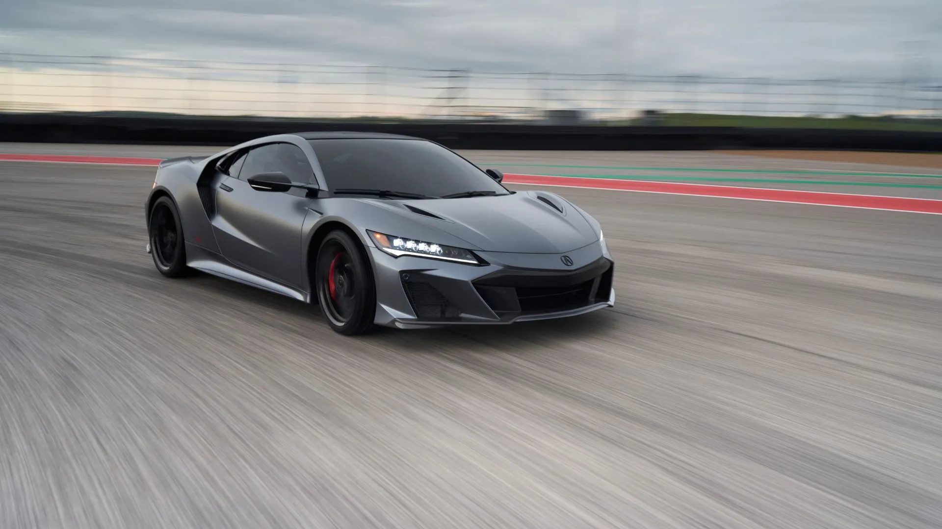 Acura NSX Type S 2022 màu xám đang lướt trên đường đua, biểu tượng của hiệu suất xe thể thao hybrid Nhật Bản.