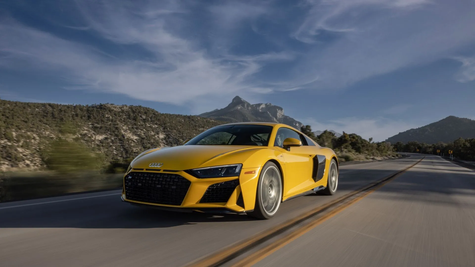 Audi R8 2022 màu vàng đang chạy, minh họa siêu xe Đức đẹp mắt nhưng có đường cong mất giá không đều