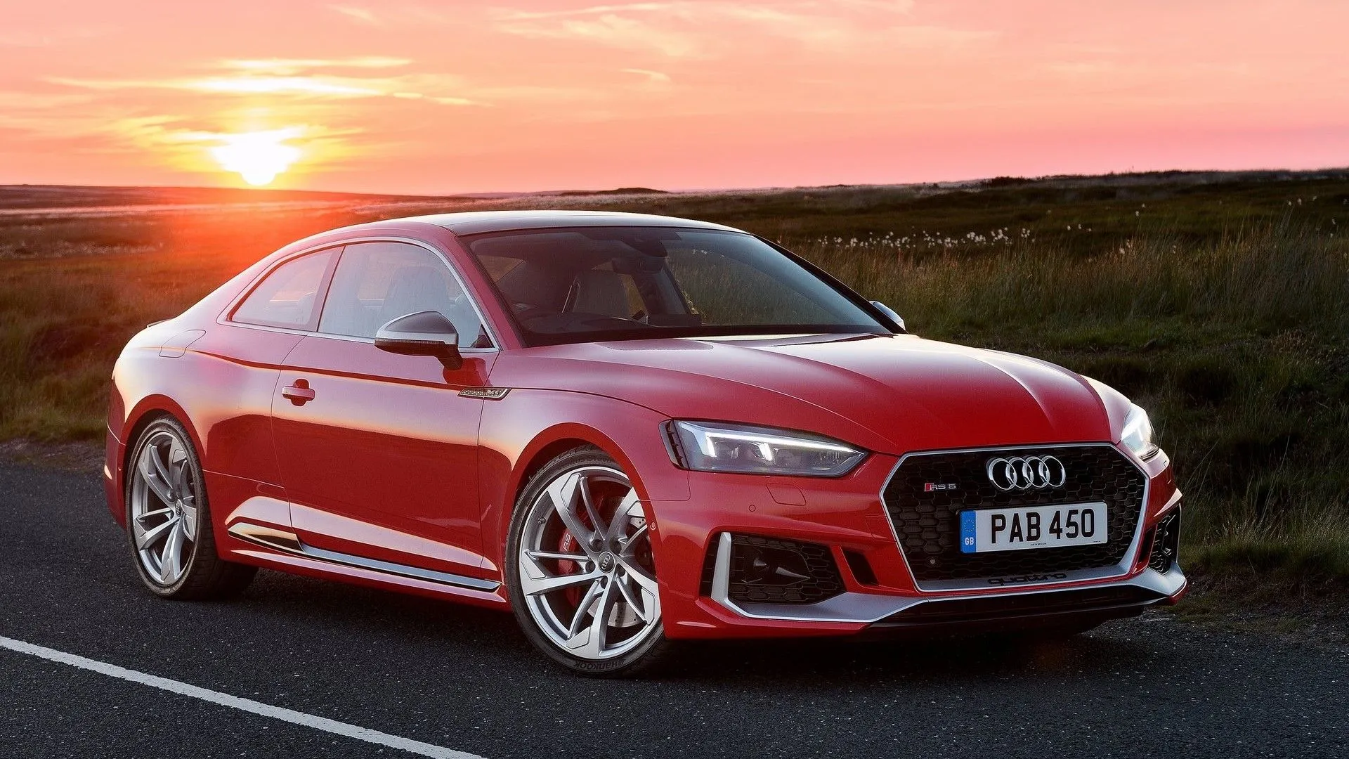 Audi RS5 Coupe 2018 màu xanh lam với thiết kế thể thao mạnh mẽ, nổi bật trên nền trời xanh
