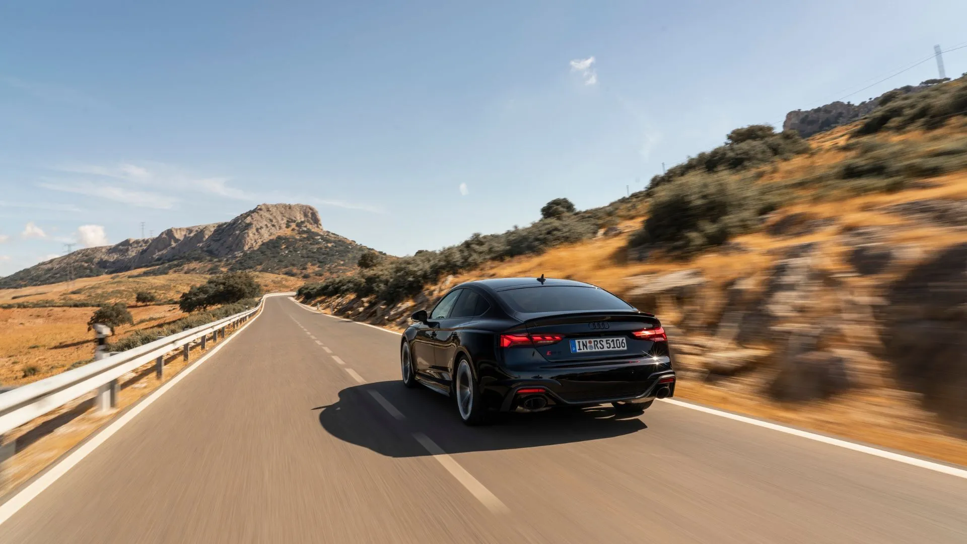 Audi RS5 Sportback màu đen trên con đường làng quanh co