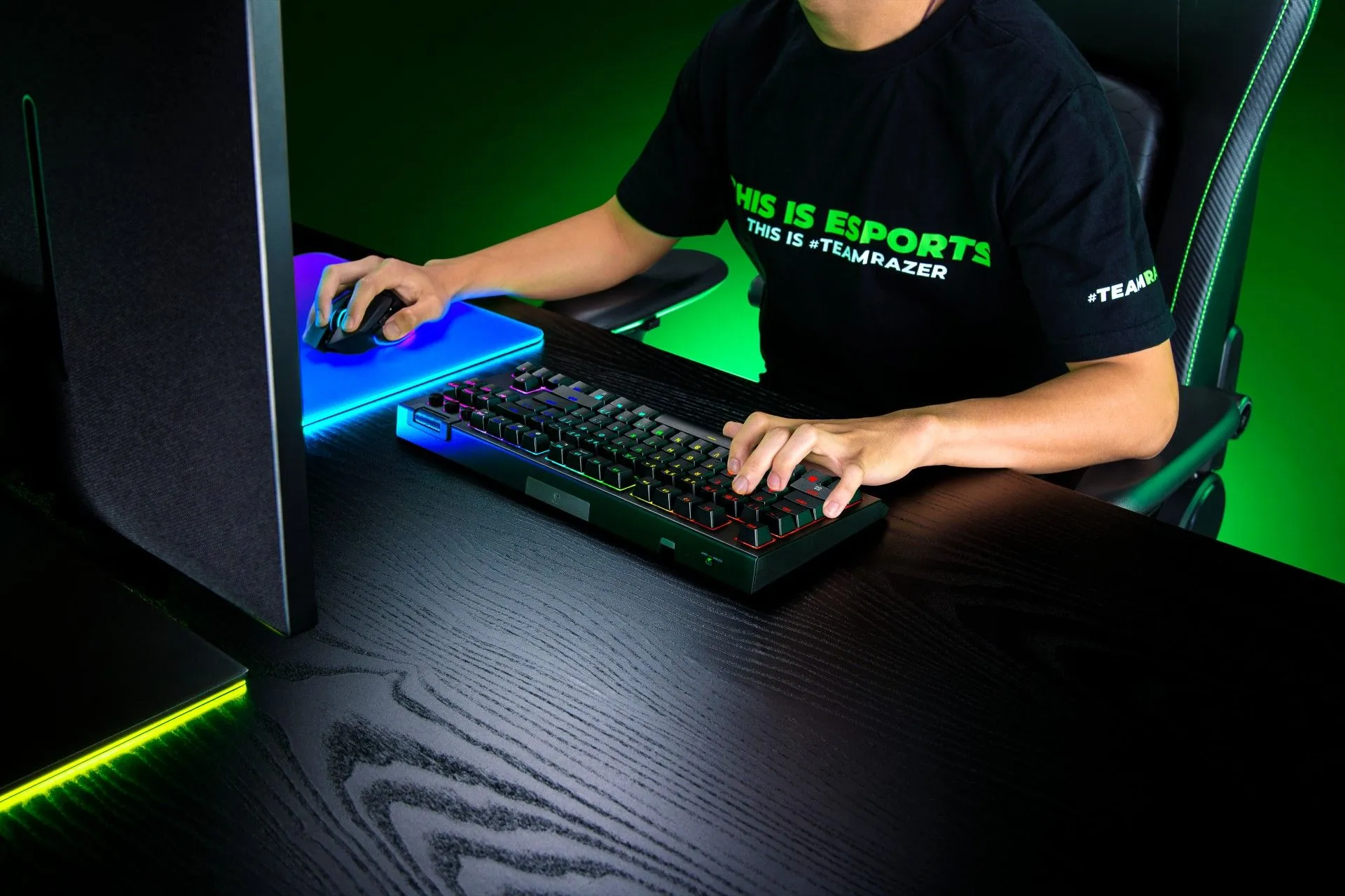 Bàn phím Razer BlackWidow V4 TKL Hyperspeed đang được sử dụng bởi một người tại bàn làm việc, ánh sáng RGB rực rỡ