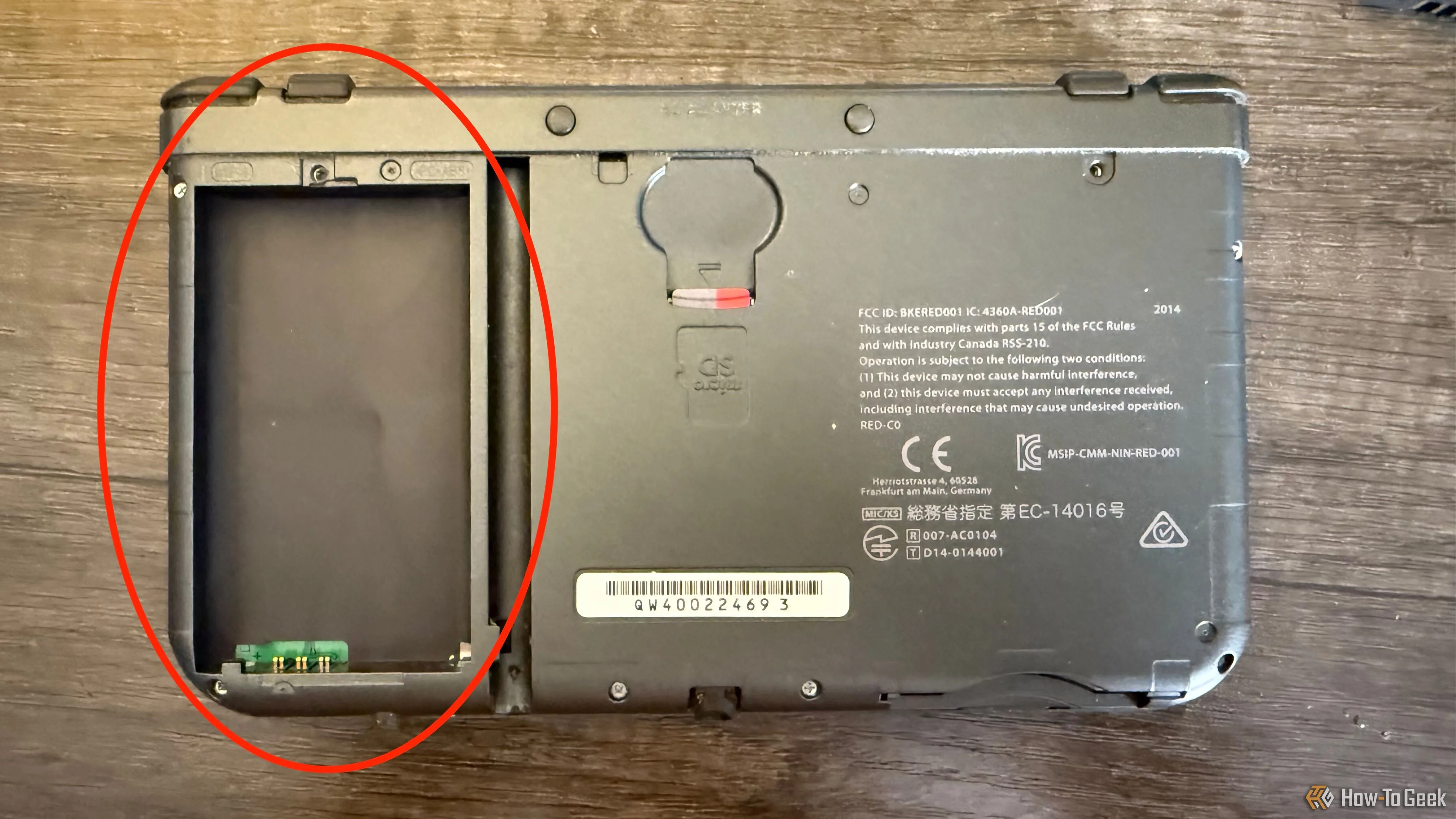 Bên trong máy New Nintendo 3DS XL đã tháo nắp, cho thấy khe cắm thẻ nhớ microSD và vị trí khay pin trống rỗng.