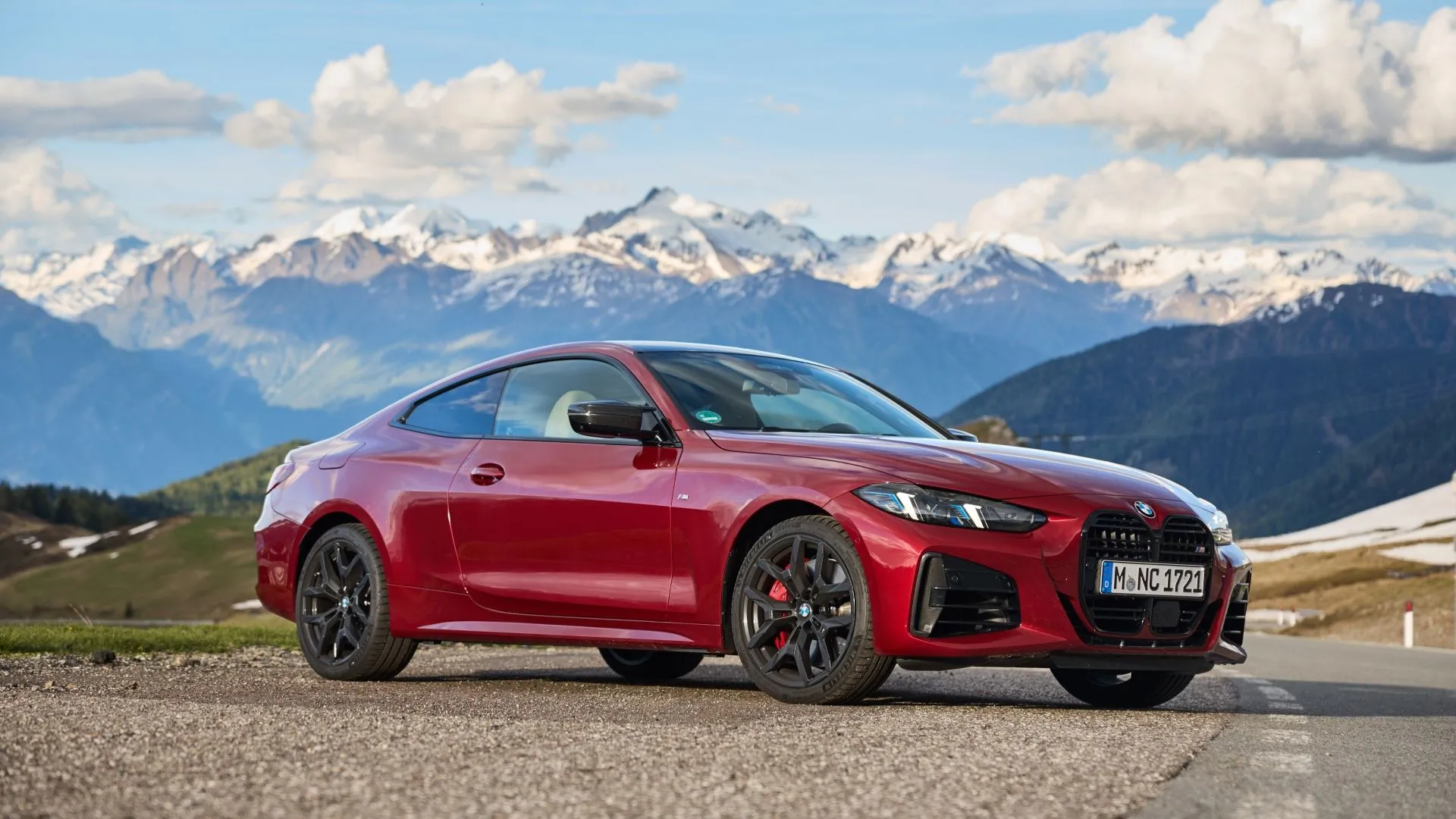 BMW 4-Series màu đỏ đỗ trước dãy núi, minh họa mẫu coupe thể thao sang trọng và mức độ mất giá nhanh