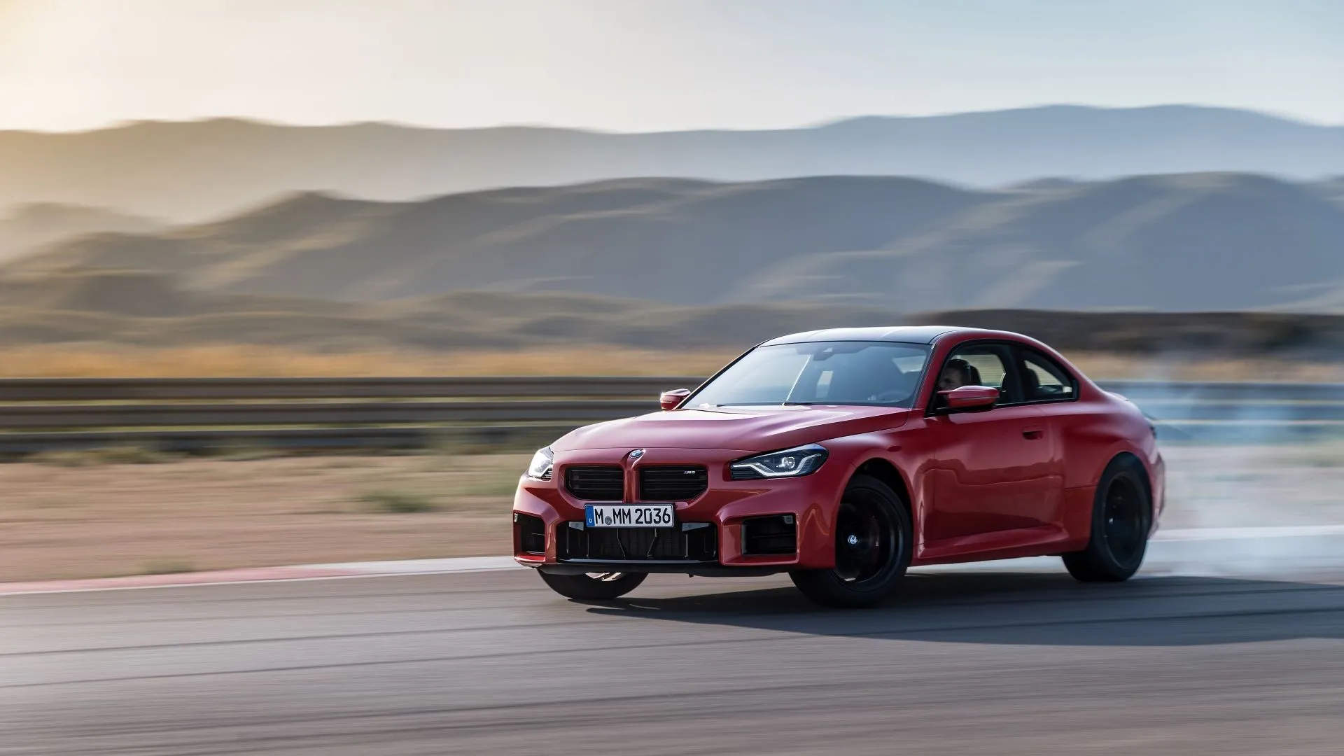 BMW M2 2025 màu đỏ đang drift qua khúc cua, thể hiện dòng xe thể thao hiệu suất cao của BMW với tỷ lệ mất giá lớn