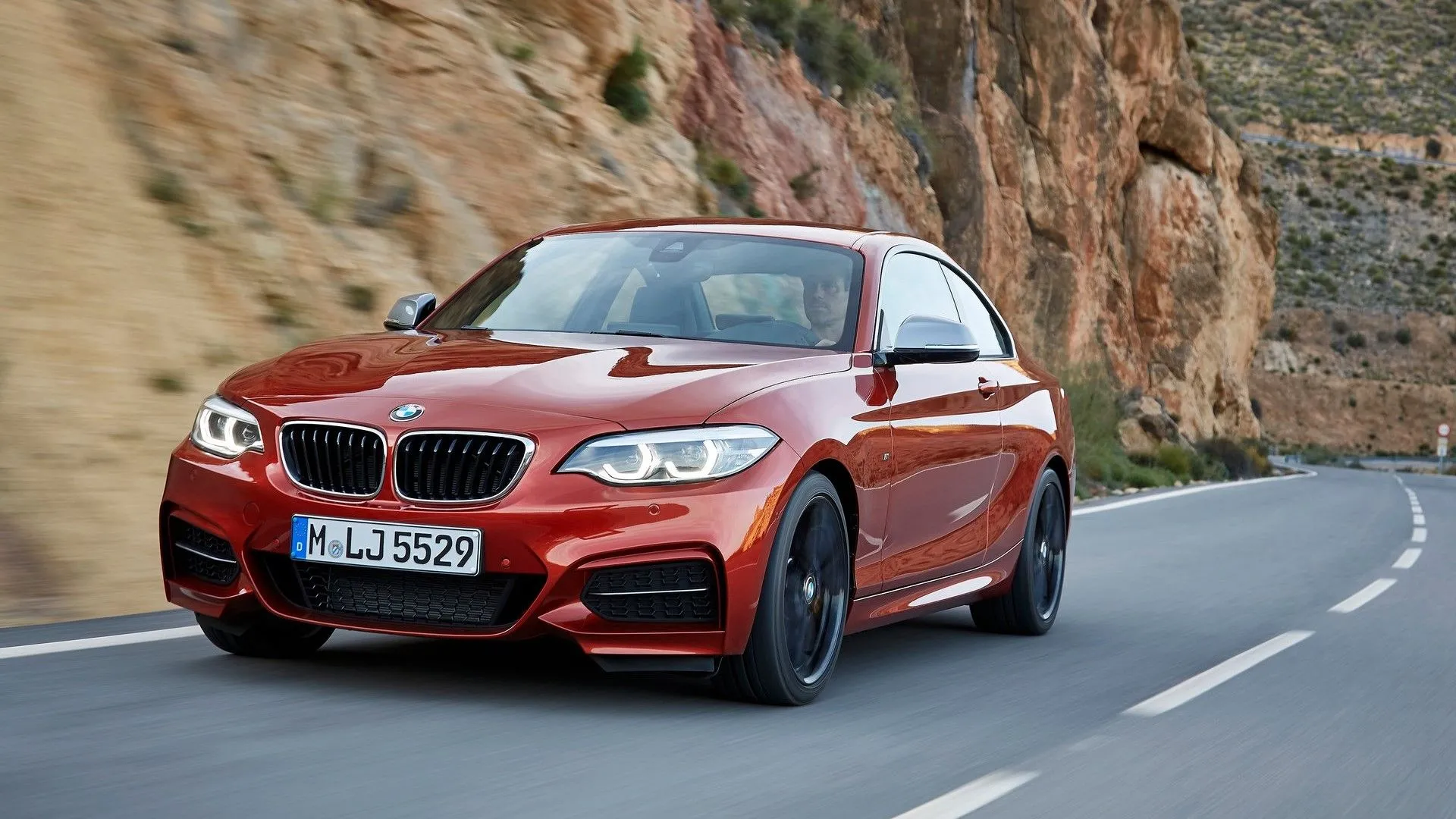 BMW M240i Coupe 2018 màu xanh đang cua gấp trên đường, nhấn mạnh khả năng xử lý thể thao
