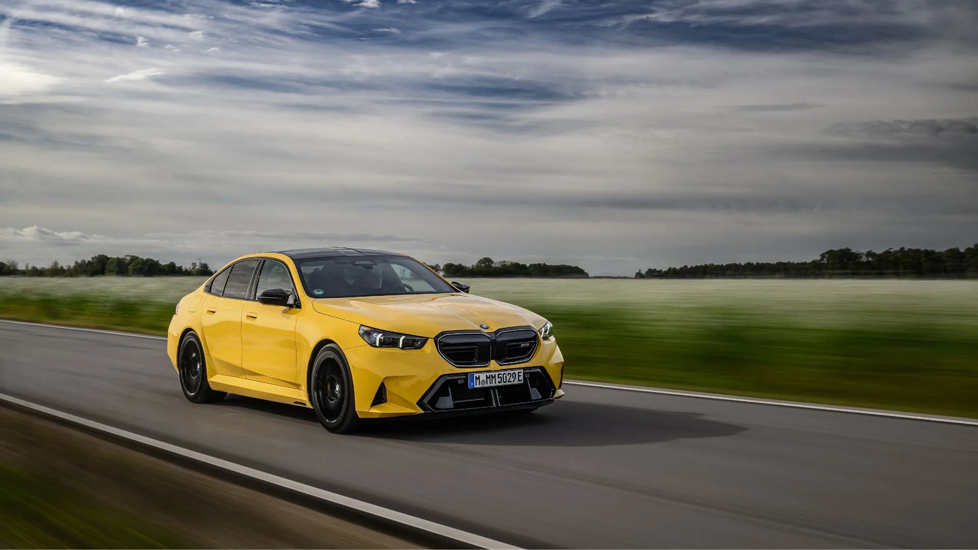 BMW M5 2025 màu vàng nổi bật trên đường quê