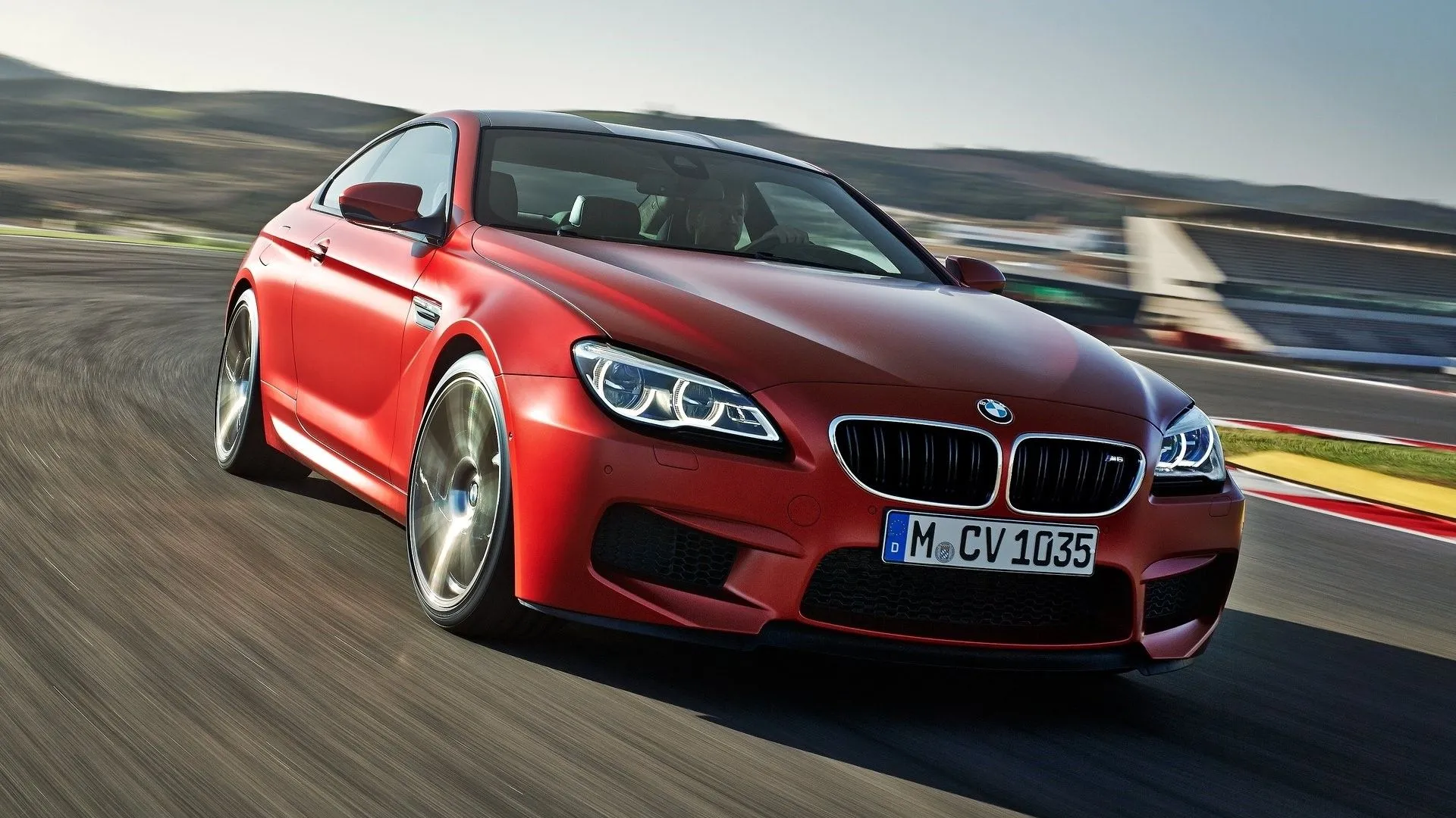 BMW M6 Coupe 2015 màu xanh dương đang di chuyển trên đường, thể hiện sự kết hợp hoàn hảo giữa hiệu suất thể thao và vẻ ngoài sang trọng