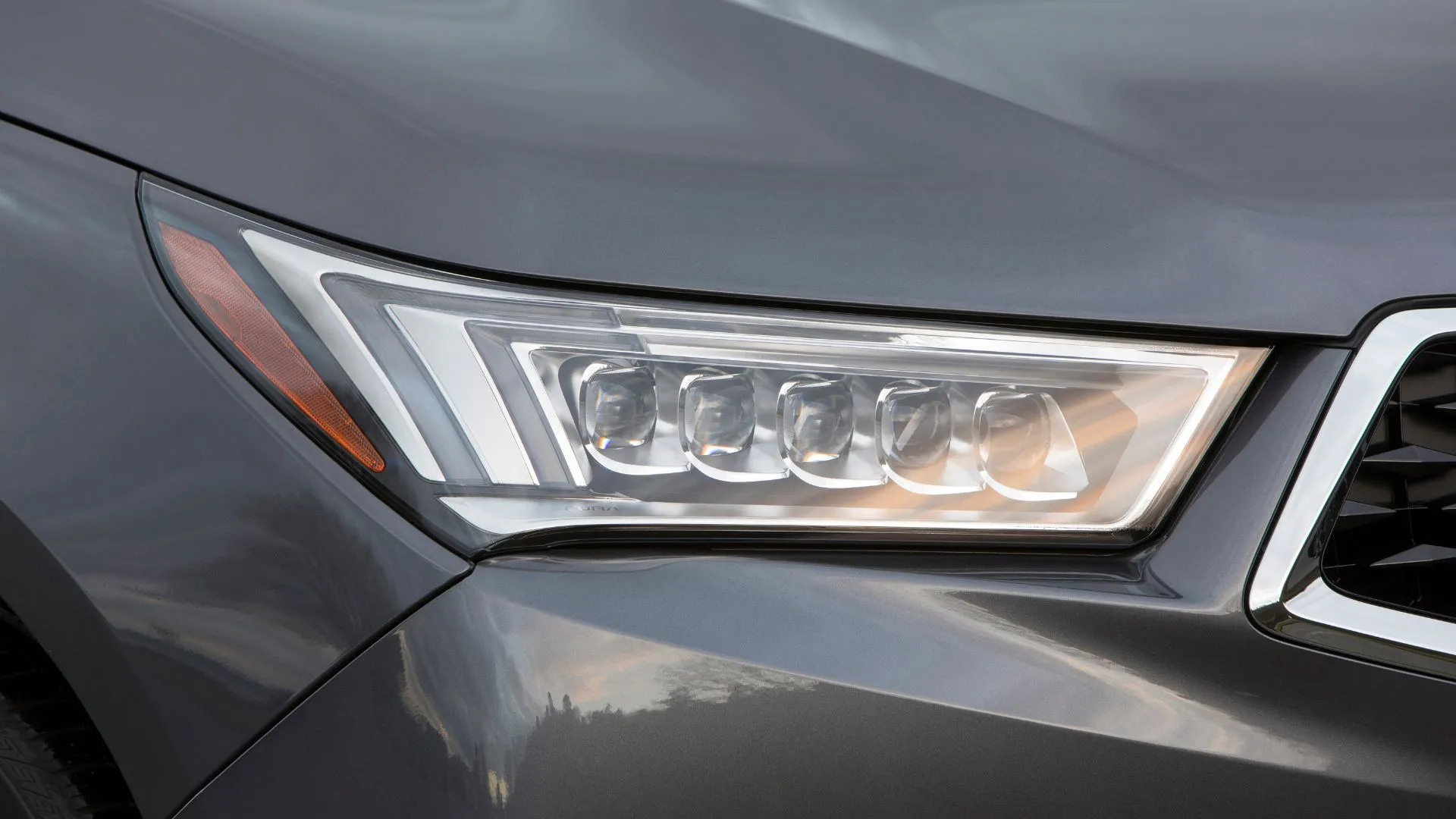 Cận cảnh đèn pha xe Acura MDX Sport Hybrid 2020 màu xám, minh họa hệ thống chiếu sáng cần hoạt động ổn định