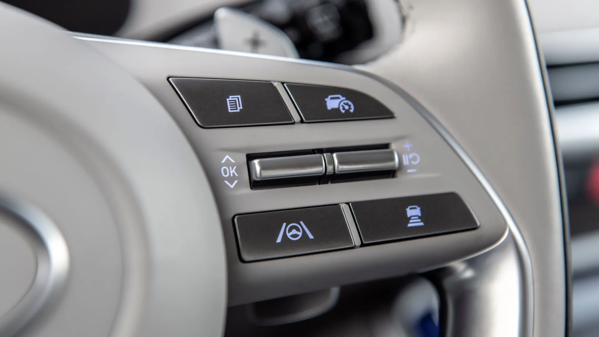 Cận cảnh vô lăng Hyundai Palisade 2025 với các nút điều khiển, thể hiện sự can thiệp của hệ thống hỗ trợ giữ làn đường.