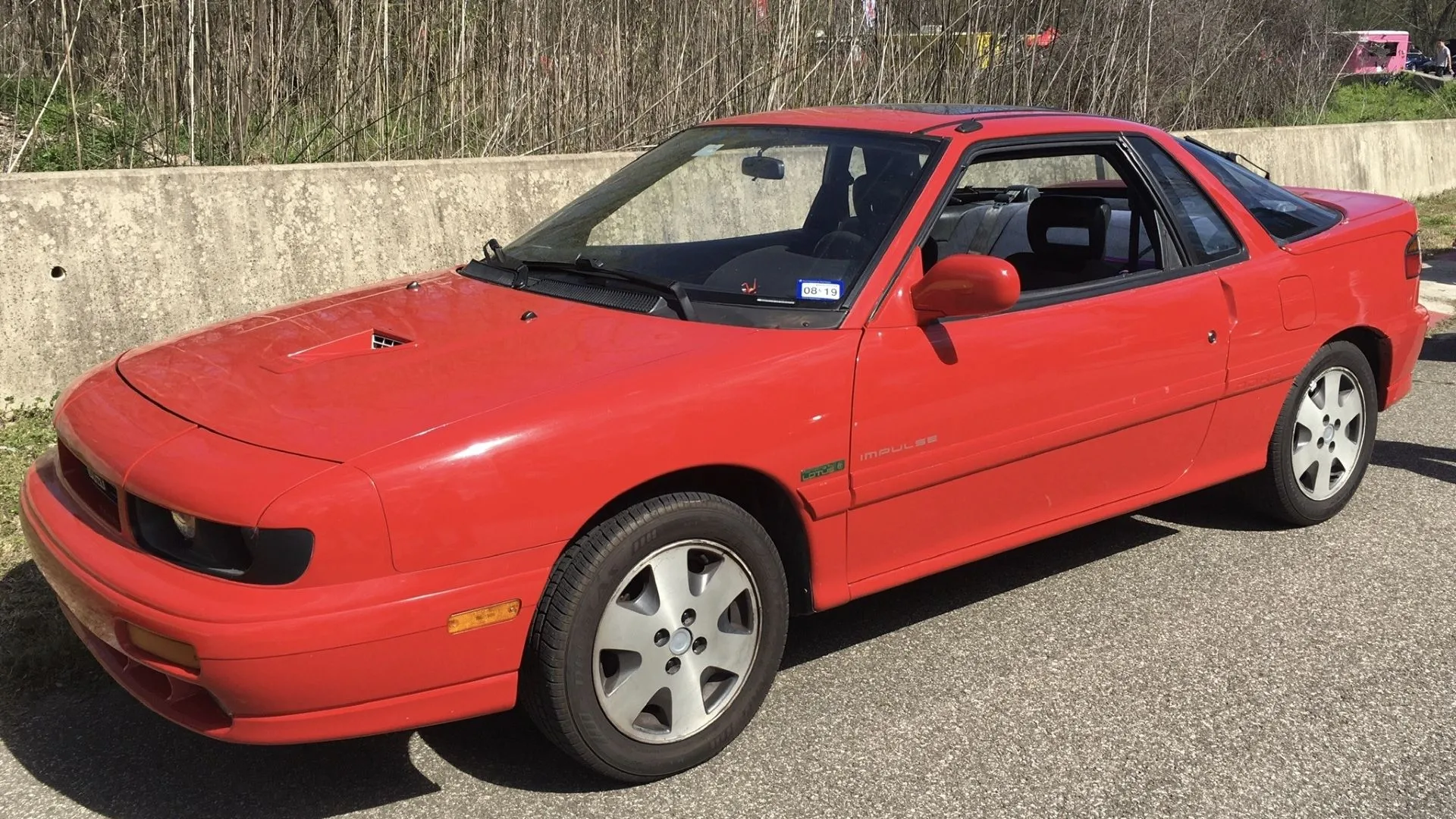 Chiếc Isuzu Impulse thế hệ thứ hai đời 1991 màu xanh lam, thể hiện sự thay đổi thiết kế và công nghệ của mẫu xe coupe thể thao này.