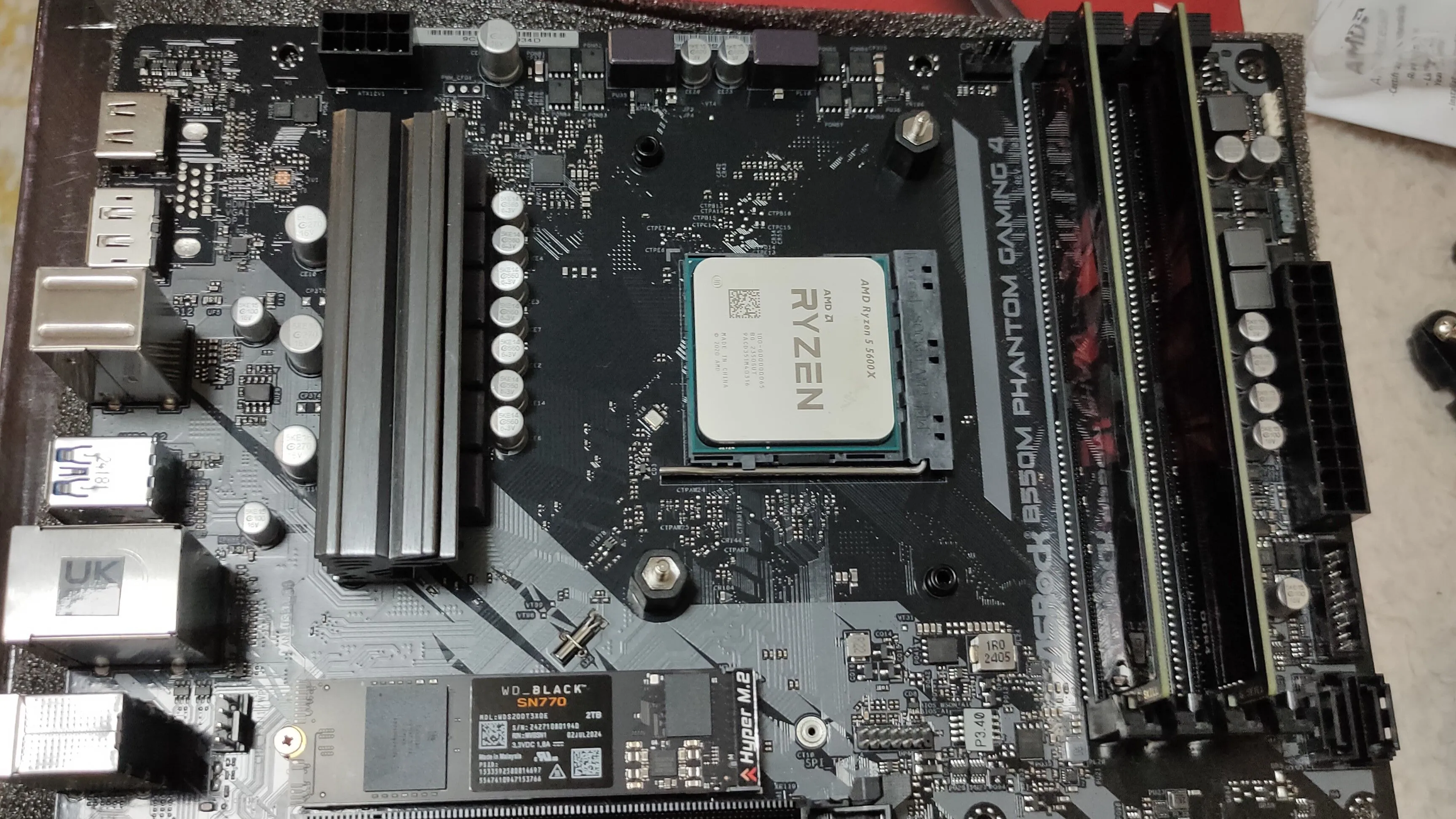 Chip xử lý Ryzen 5 5600X trên bo mạch chủ B550M cùng RAM DDR4 và SSD NVMe, đại diện cho việc xây dựng PC gaming tiết kiệm.