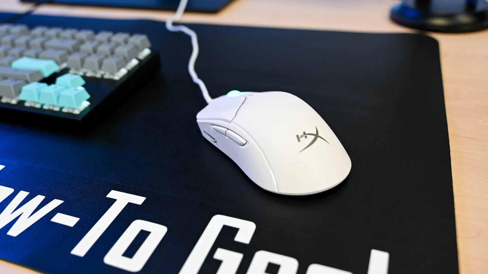 Chuột gaming HyperX Haste 2 trên thảm lót bàn dày, đảm bảo theo dõi chính xác và mượt mà trong mọi thao tác.