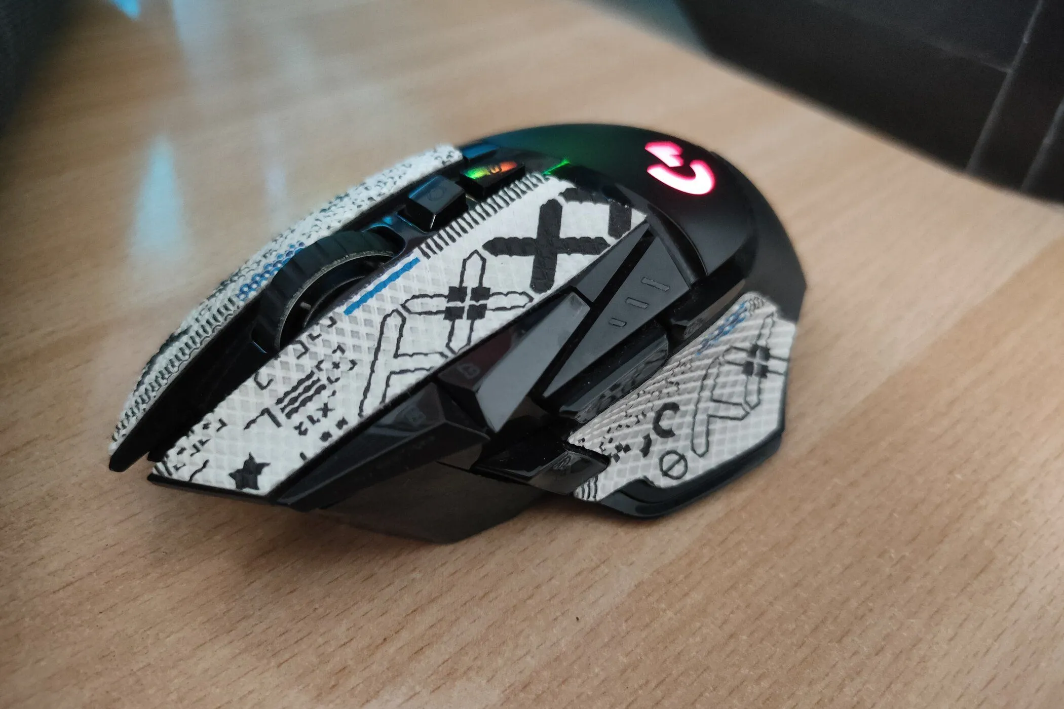 Chuột gaming Logitech G502 Lightspeed Wireless trên bàn gỗ, sẵn sàng để dán grip tape.