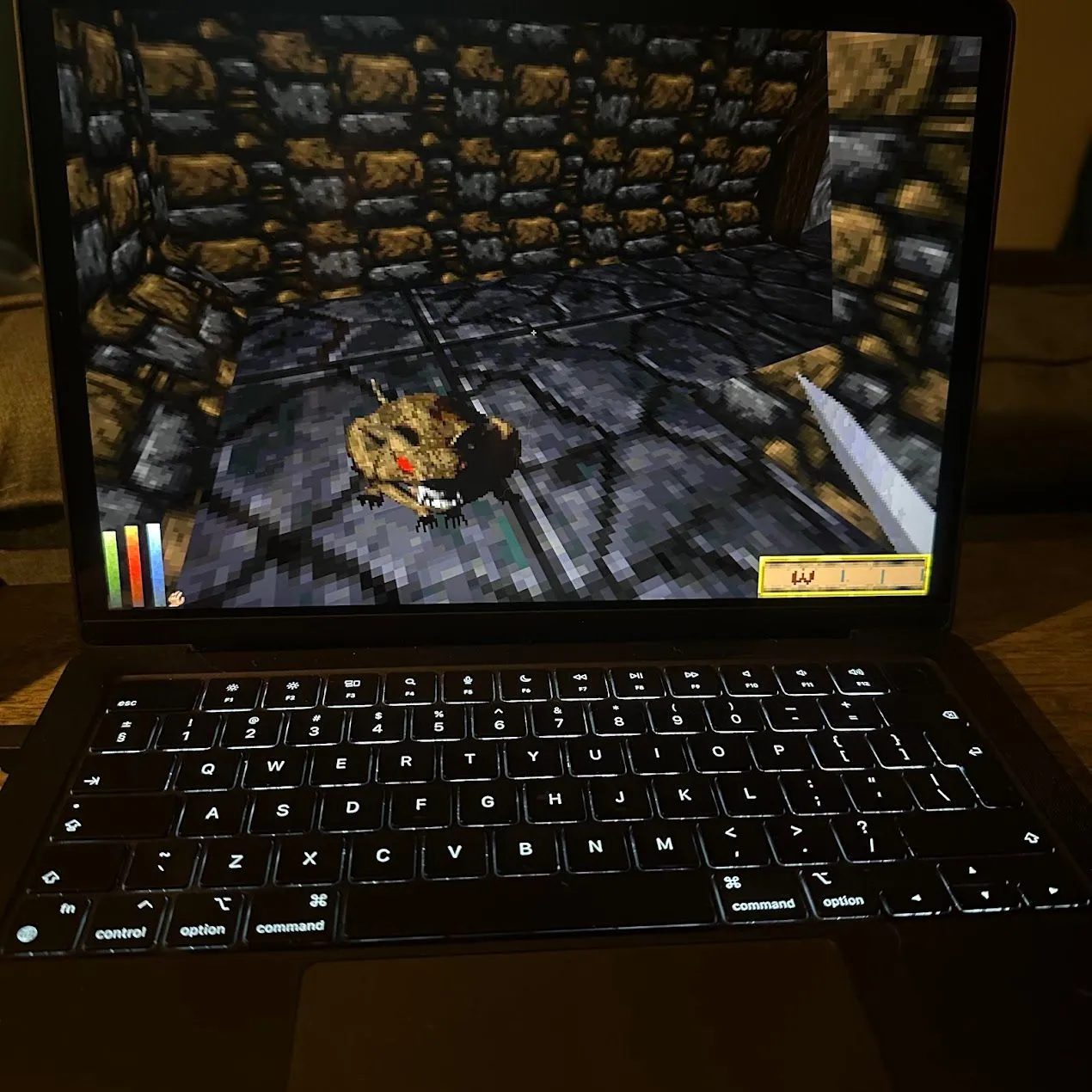 Daggerfall Unity đang chạy trên MacBook Pro, hiển thị môi trường 3D của game nhập vai cổ điển với một hiệp sĩ đang chiến đấu trong hang động.
