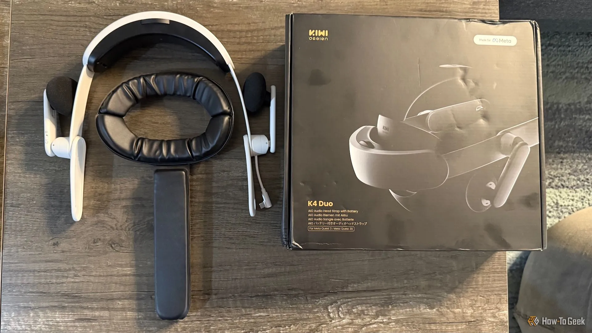Dây đeo KIWI K4 Duo và hộp sản phẩm trên bàn, thể hiện tổng quan về phụ kiện VR này