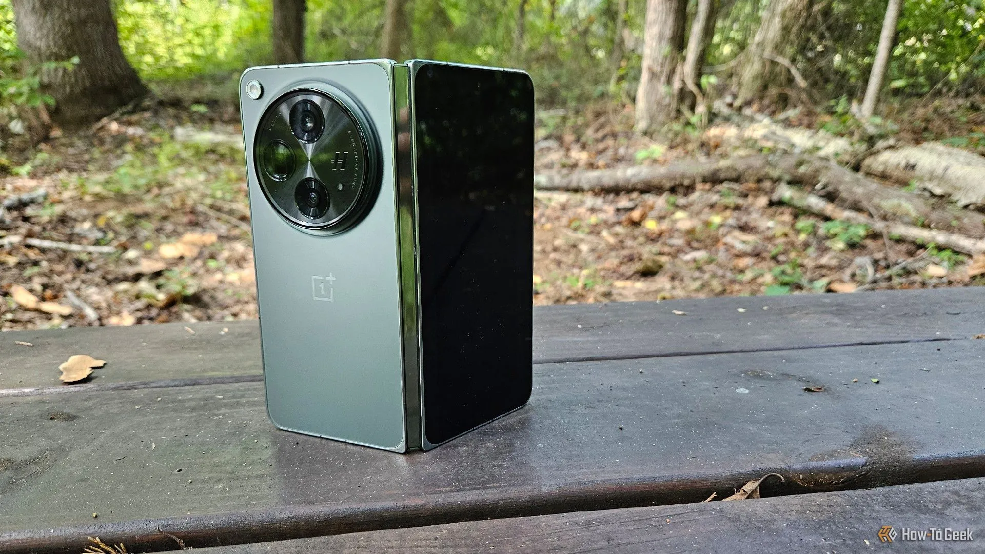 Điện thoại OnePlus Open đặt đứng trên ghế gỗ, thể hiện kiểu dáng khi gập