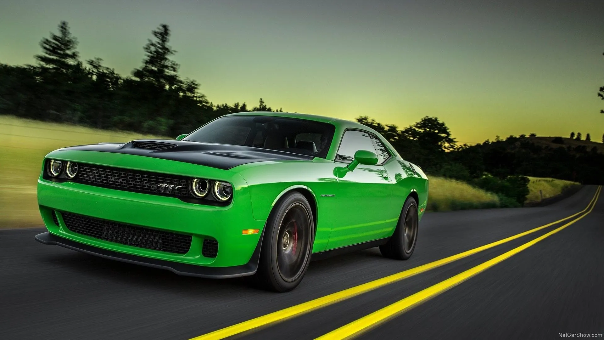 Dodge Challenger SRT Hellcat 2015 màu xanh lá đậm đang di chuyển nhanh, biểu tượng của sức mạnh cơ bắp Mỹ