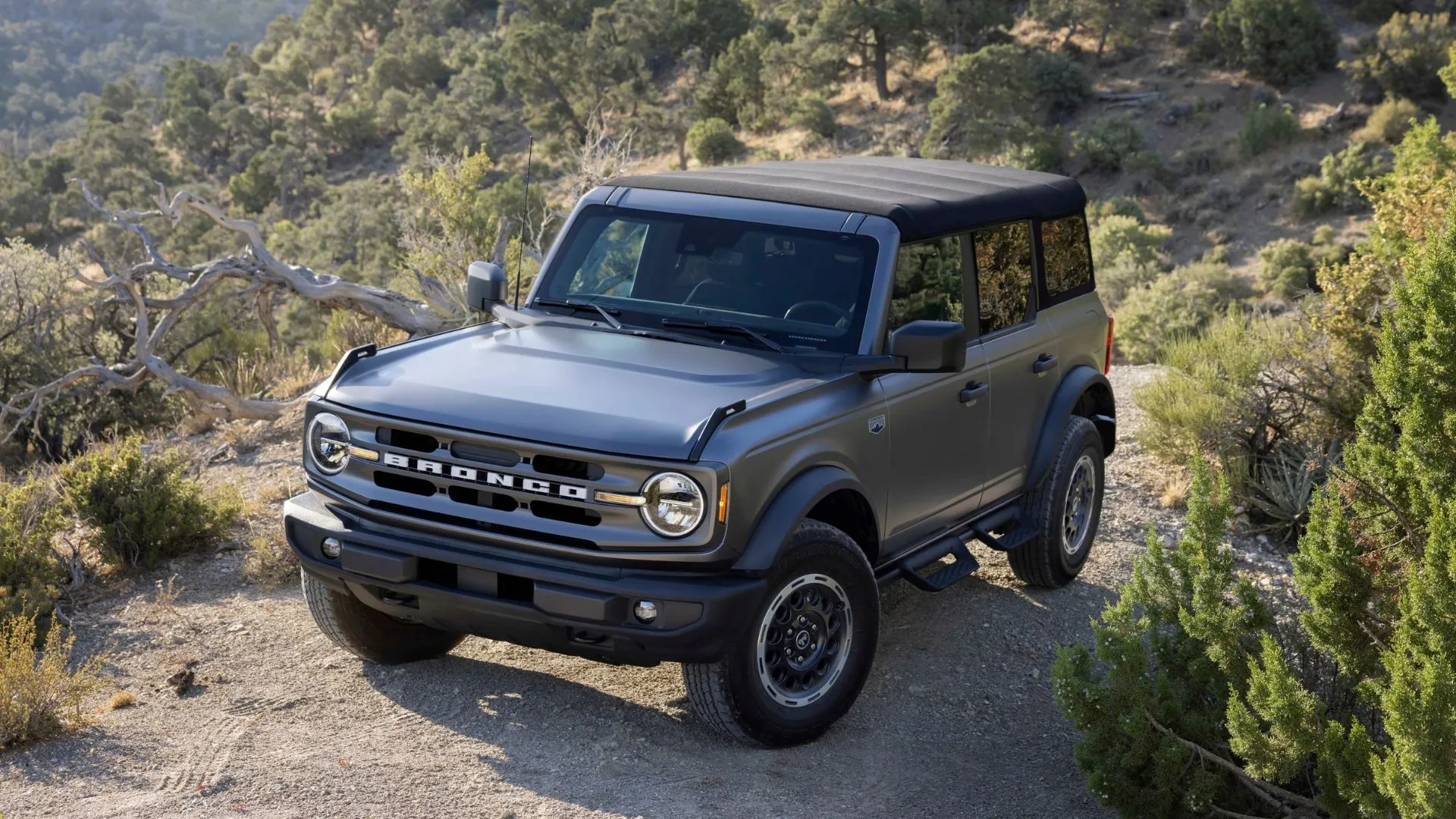 Ford Bronco 2025 màu vàng cam đang vượt địa hình gồ ghề, thể hiện khả năng off-road vượt trội.