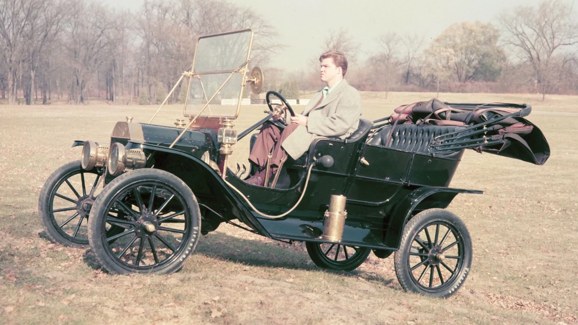 Ford Model T đời 1908, chiếc xe đầu tiên được sản xuất hàng loạt, di chuyển trên đồng cỏ.