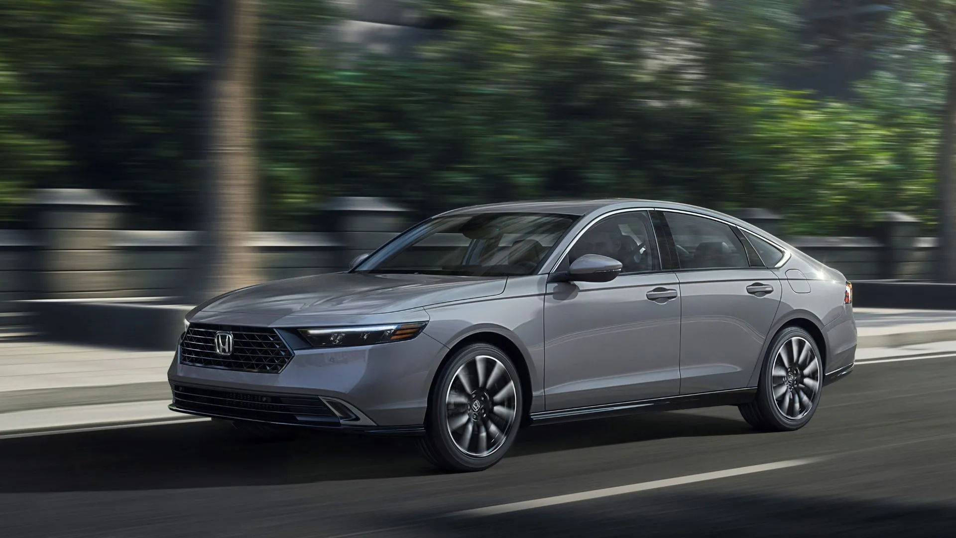 Góc 3/4 phía trước của Honda Accord Touring 2025 màu xám, đang di chuyển trong thành phố, nổi bật với thiết kế sang trọng và hiệu quả vận hành.