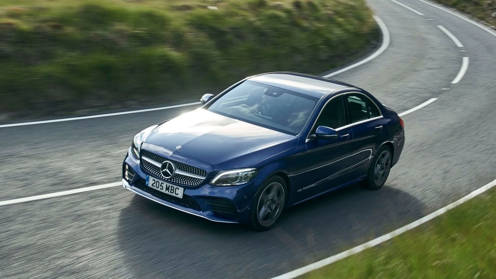 Góc 3/4 phía trước của một chiếc Mercedes-Benz C-Class 2019 màu xám trên đường