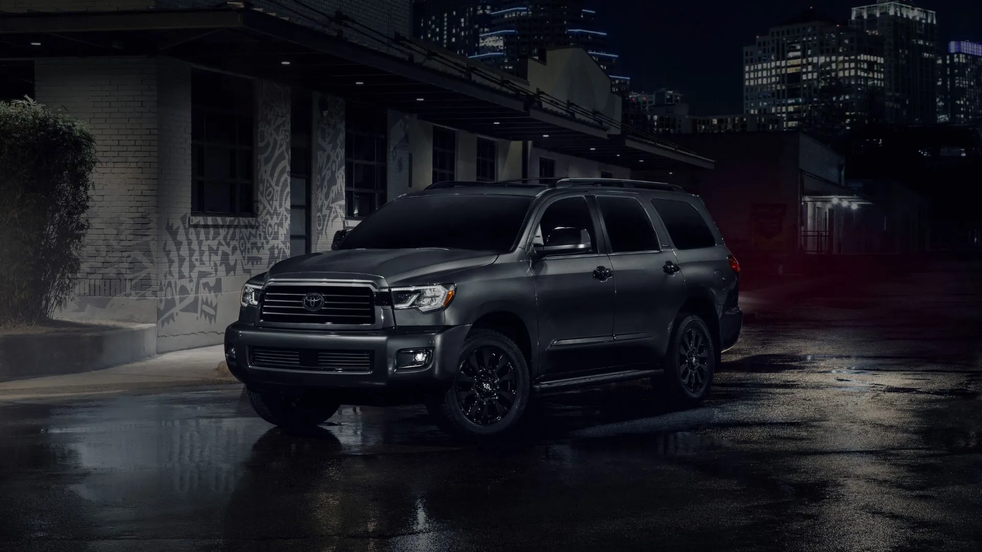 Góc ba phần tư phía trước của chiếc Toyota Sequoia 2022 màu đen đậu trong bóng tối.