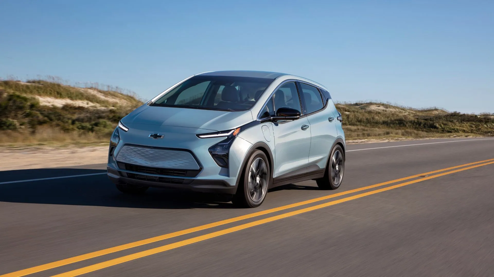 Góc nhìn 3/4 phía trước của Chevrolet Bolt EV 2022 màu bạc đang lăn bánh trên đường nông thôn, minh họa vẻ ngoài đáng tin cậy và sẵn sàng vận hành.