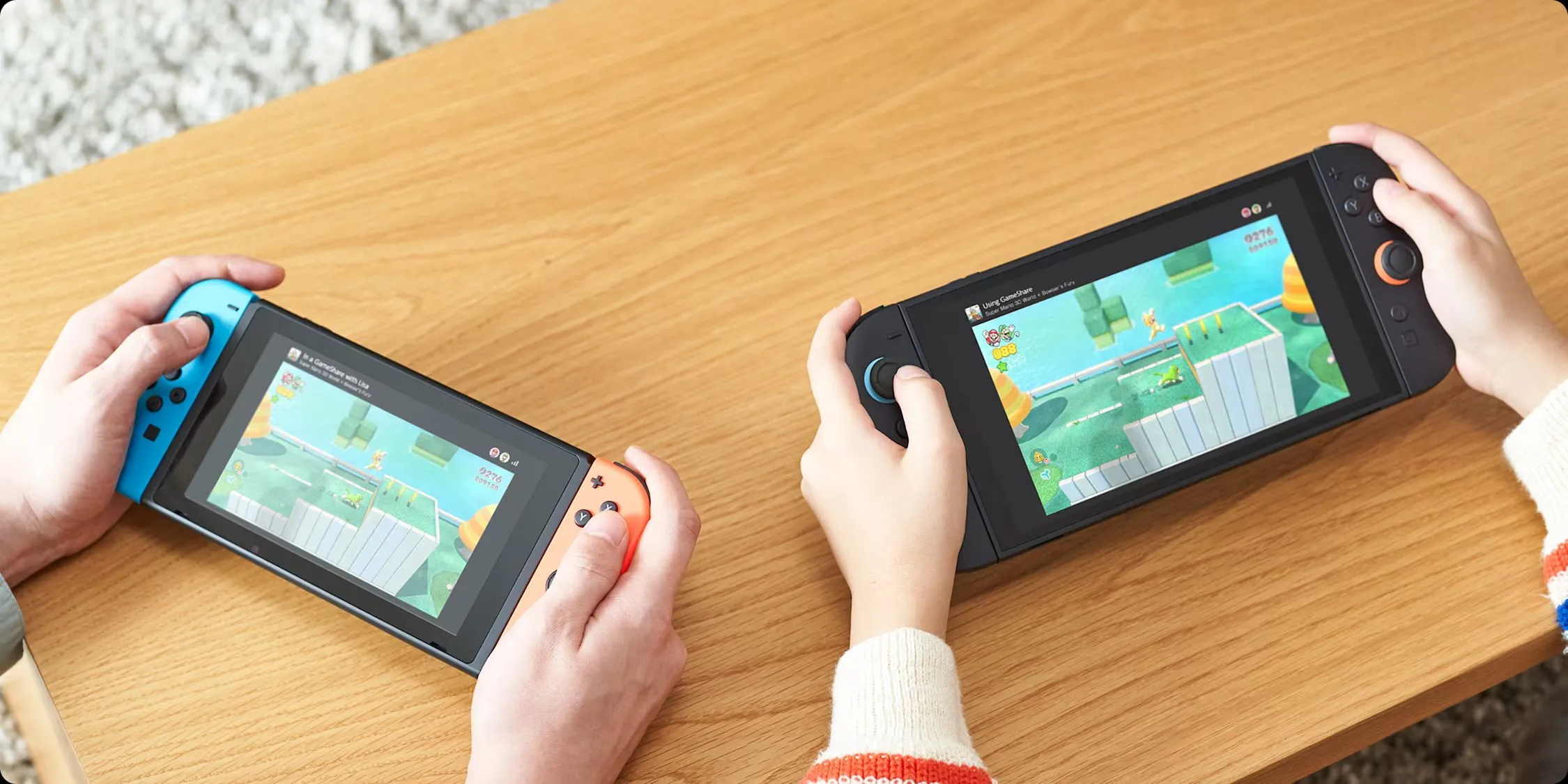 Hai máy chơi game Nintendo Switch 2 và Switch đời đầu đang kết nối qua tính năng GameShare, thể hiện khả năng chia sẻ game tiện lợi.