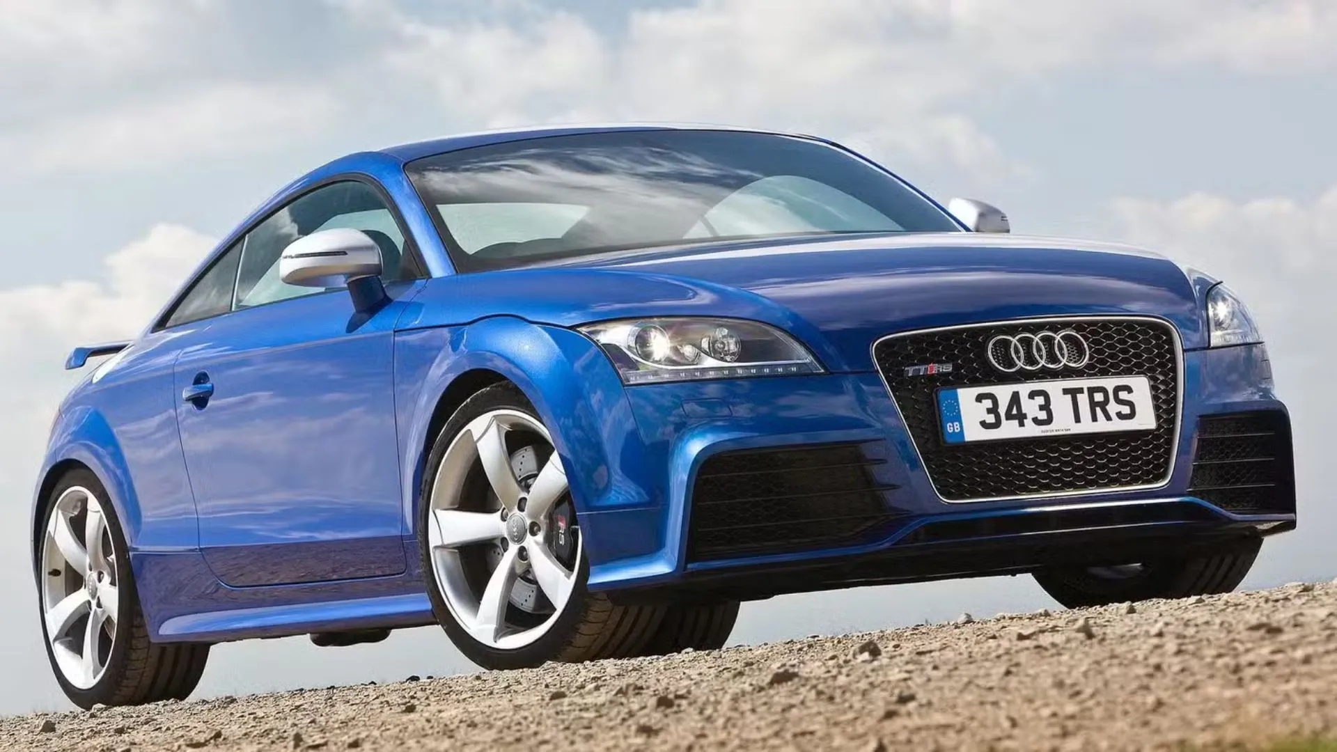Hình ảnh Audi TT RS màu xanh dương với thiết kế thể thao mạnh mẽ đậu trên nền sỏi