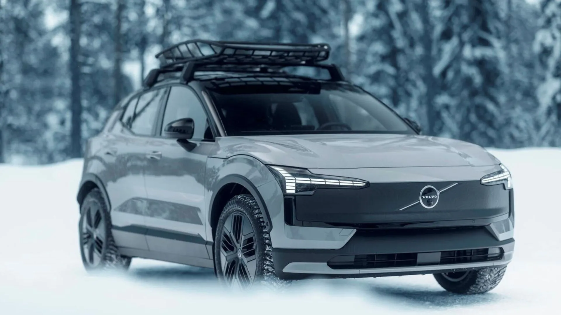 Hình ảnh mặt trước ba phần tư năng động của một chiếc Volvo EX30 Cross Country màu bạc đang lái trong tuyết.