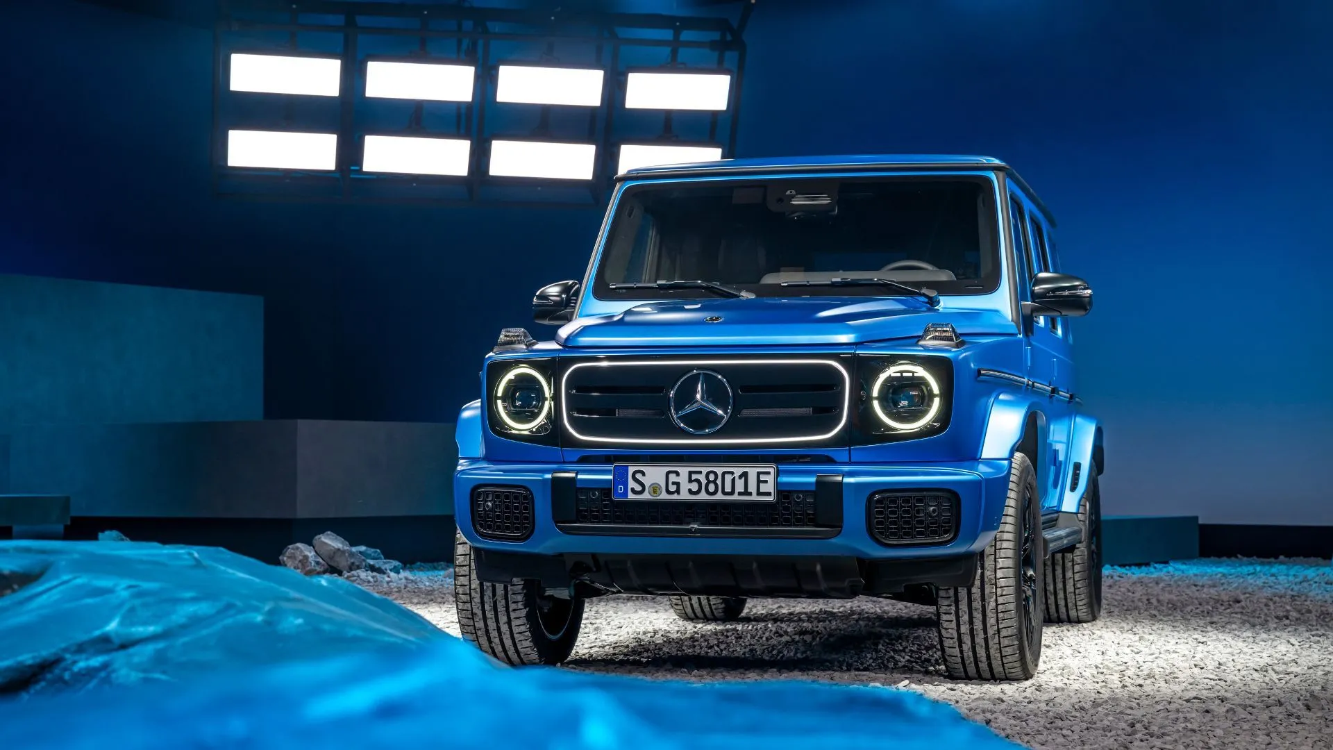 Hình ảnh mặt trước ba phần tư tĩnh của một chiếc Mercedes-Benz G580 EQ màu xanh lam trong bối cảnh studio.