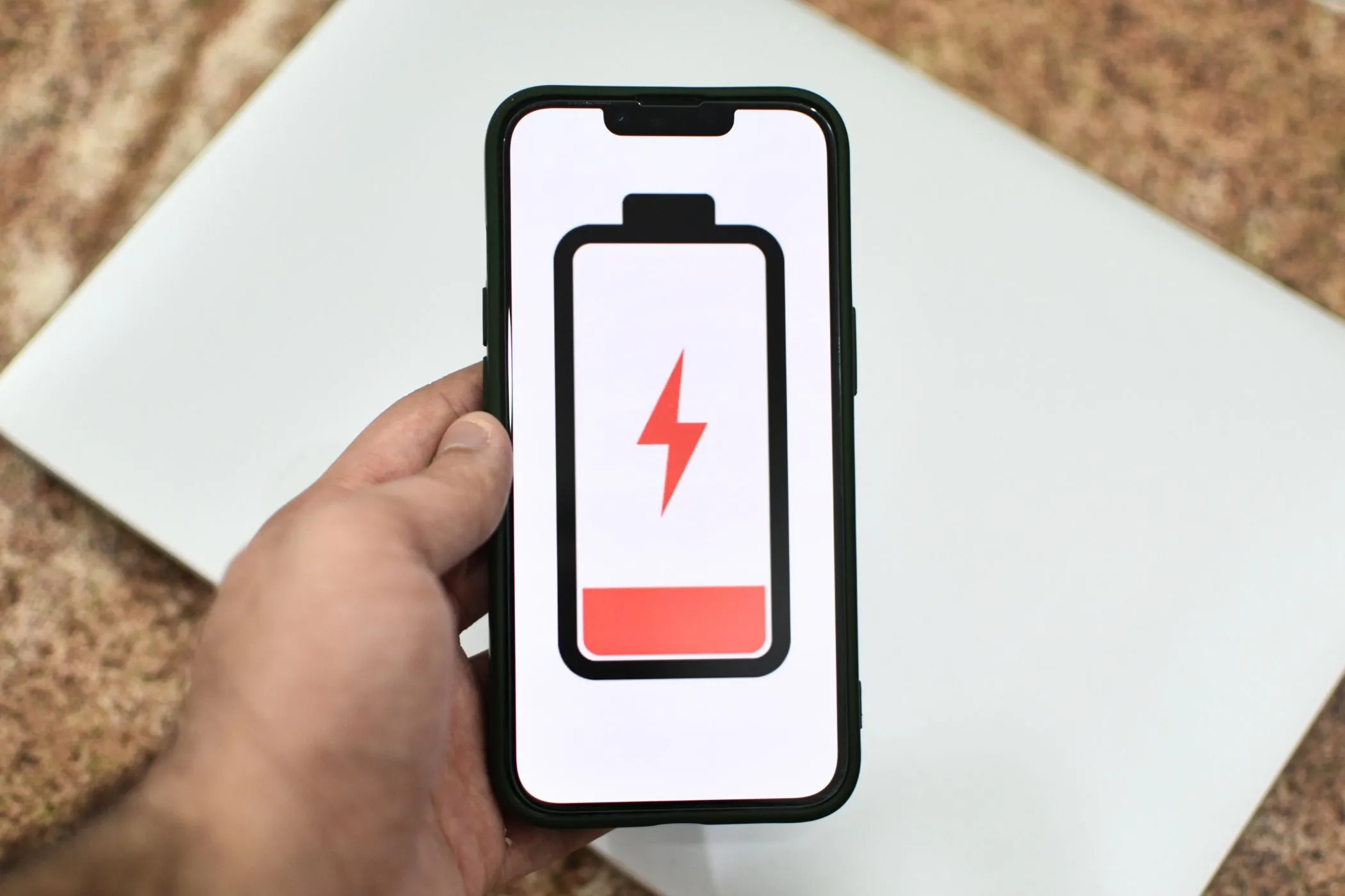 Hình ảnh minh họa iPhone với biểu tượng pin yếu, tượng trưng cho vấn đề hao pin nghiêm trọng trên iOS Developer Beta