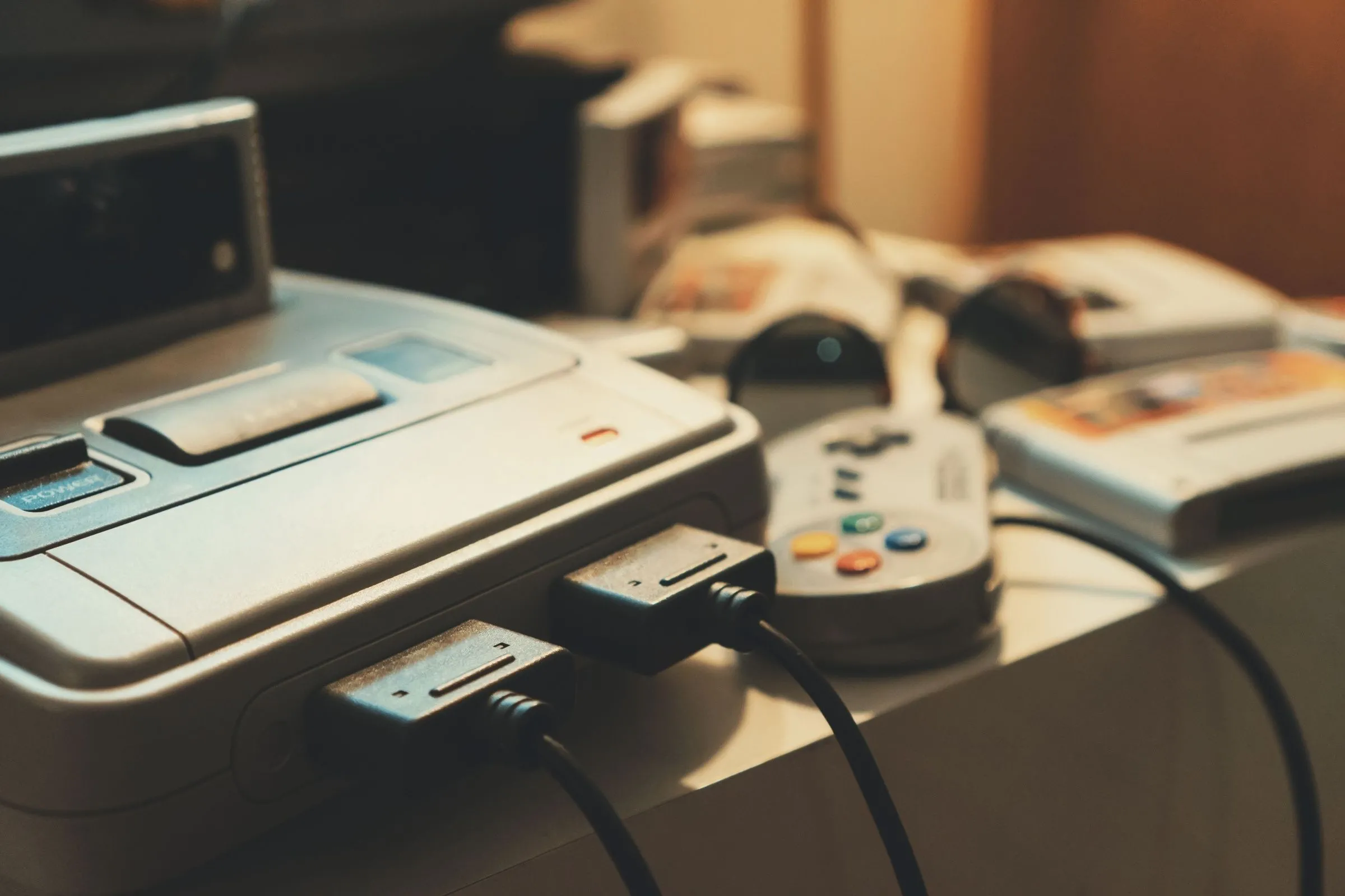 Hình ảnh một máy chơi game retro với tay cầm và băng game, thể hiện sự hoài cổ nhưng cũng ẩn chứa những giới hạn của console giả lập.