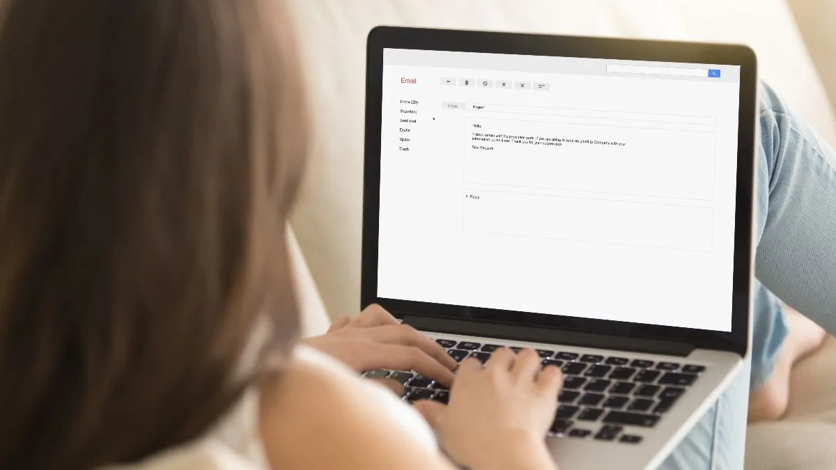 Hình ảnh người phụ nữ đang soạn email trên laptop, thể hiện hành động gửi thư và sự chờ đợi phản hồi.