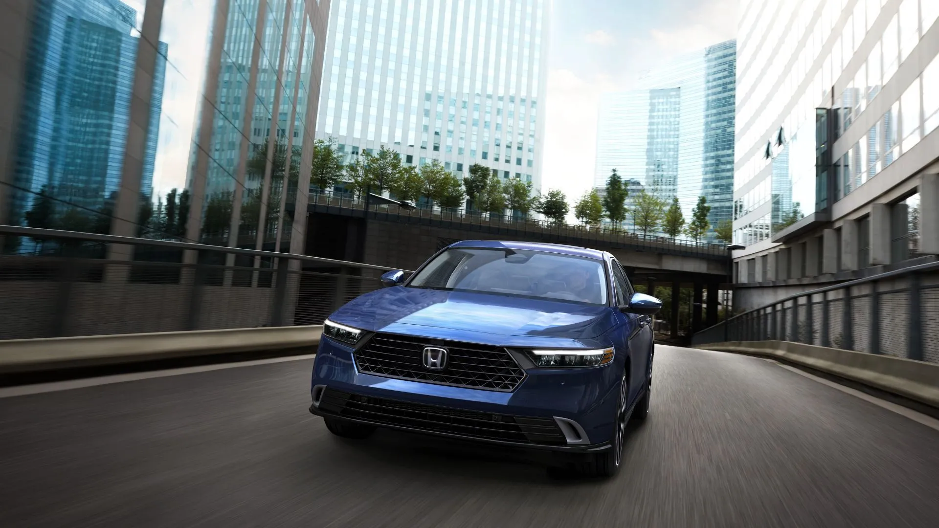 Honda Accord Touring 2023 màu xanh dương năng động di chuyển trên đường phố, biểu tượng cho khả năng tiết kiệm nhiên liệu ấn tượng