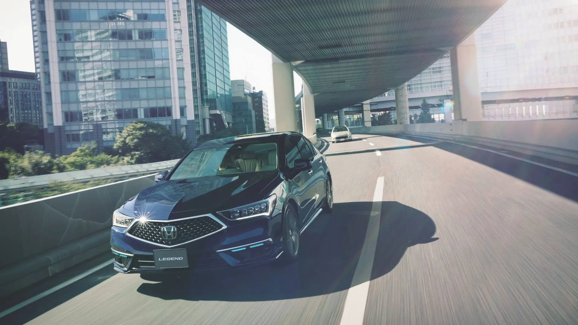 Honda Legend 2021 màu xanh lam đang di chuyển dưới cầu thành phố, thể hiện sự thanh lịch và công nghệ cao cấp của Honda.